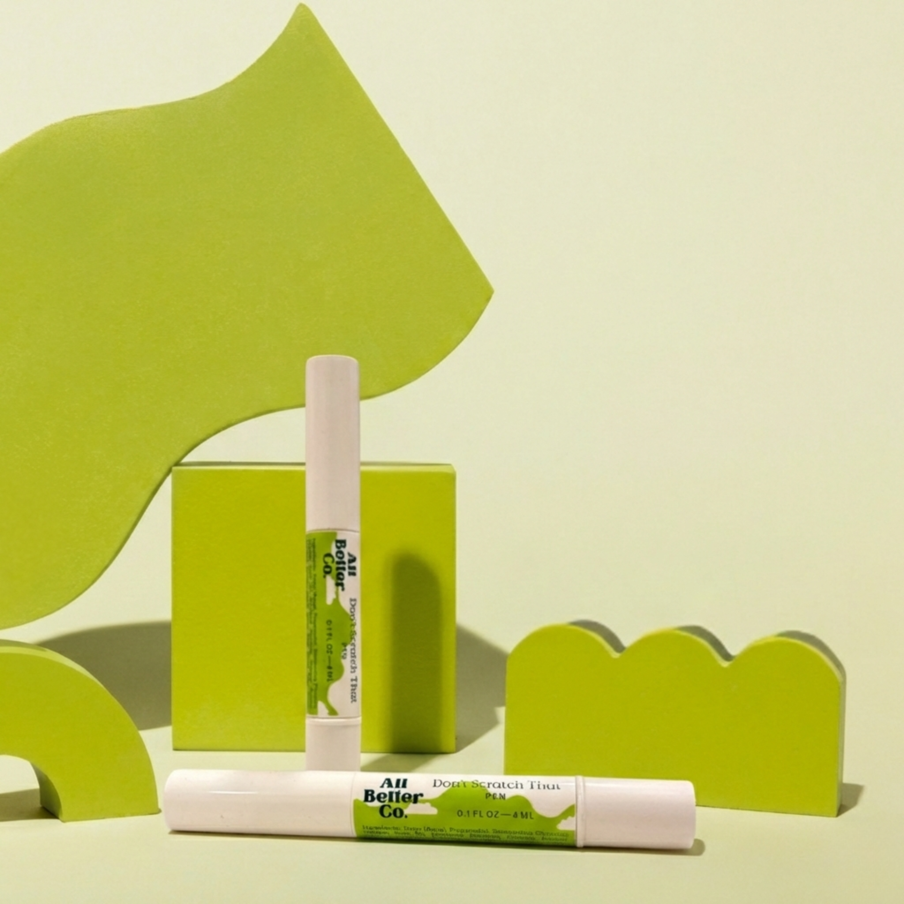 Two lip products with green and white design on a light green background