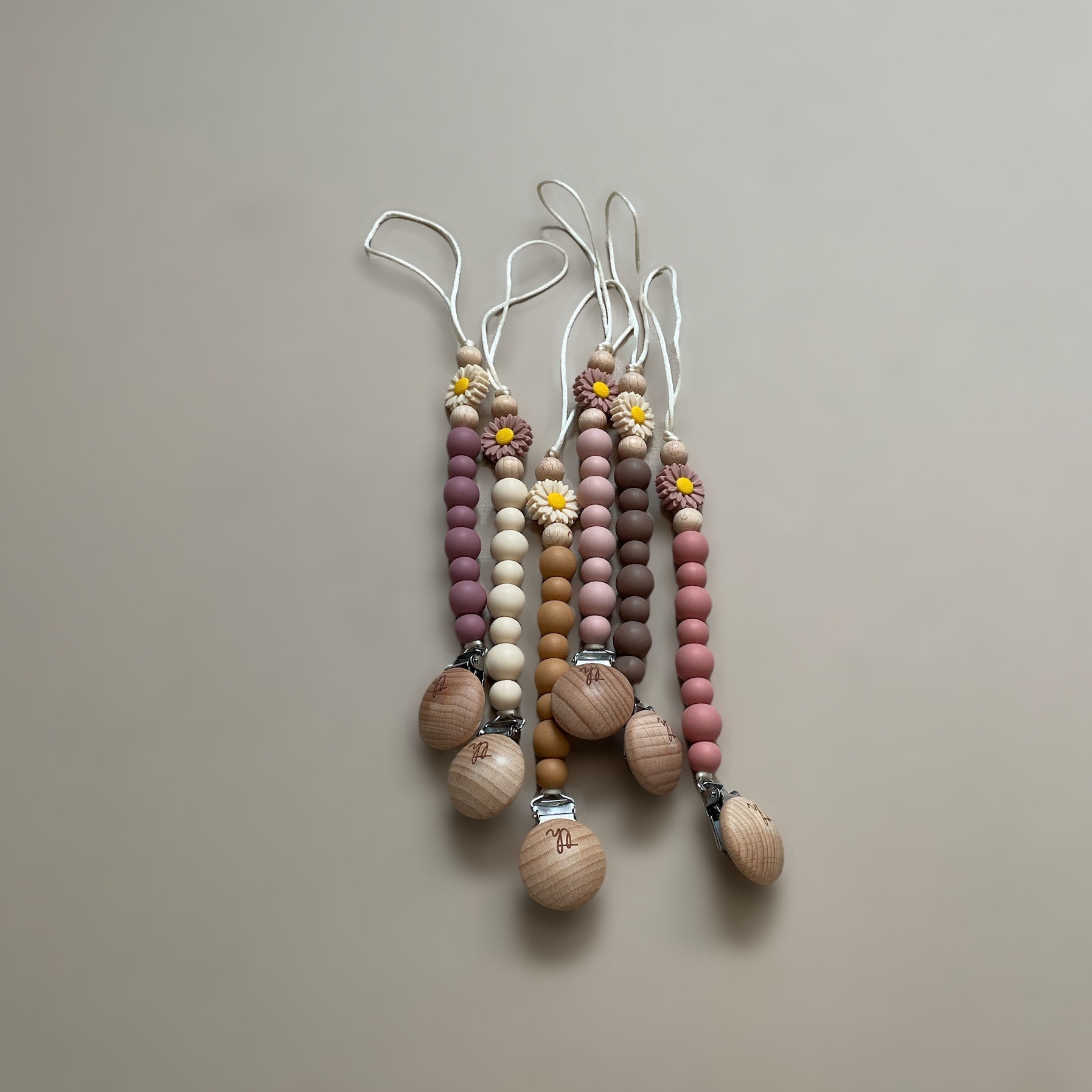 Set of wooden and beaded keychains on a beige background