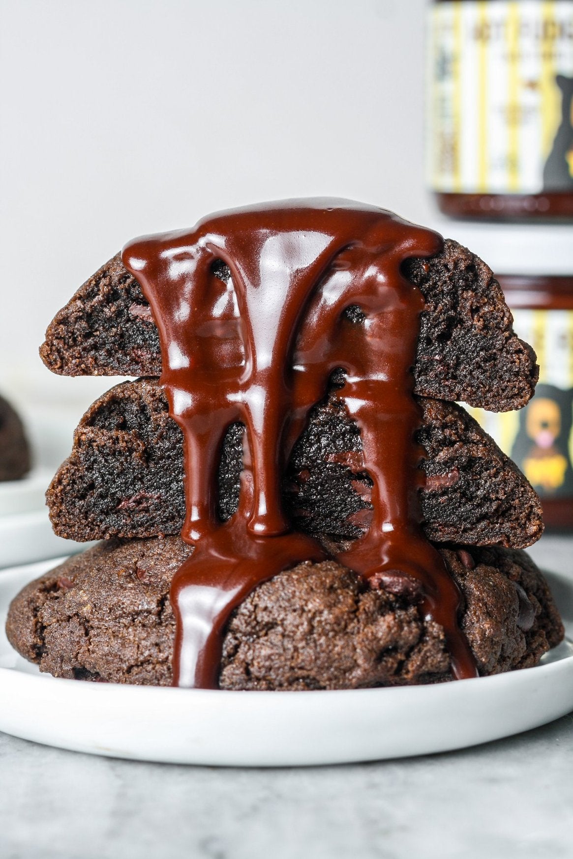 Stack of chocolate cake with a drizzle of chocolate sauce on a white plate.