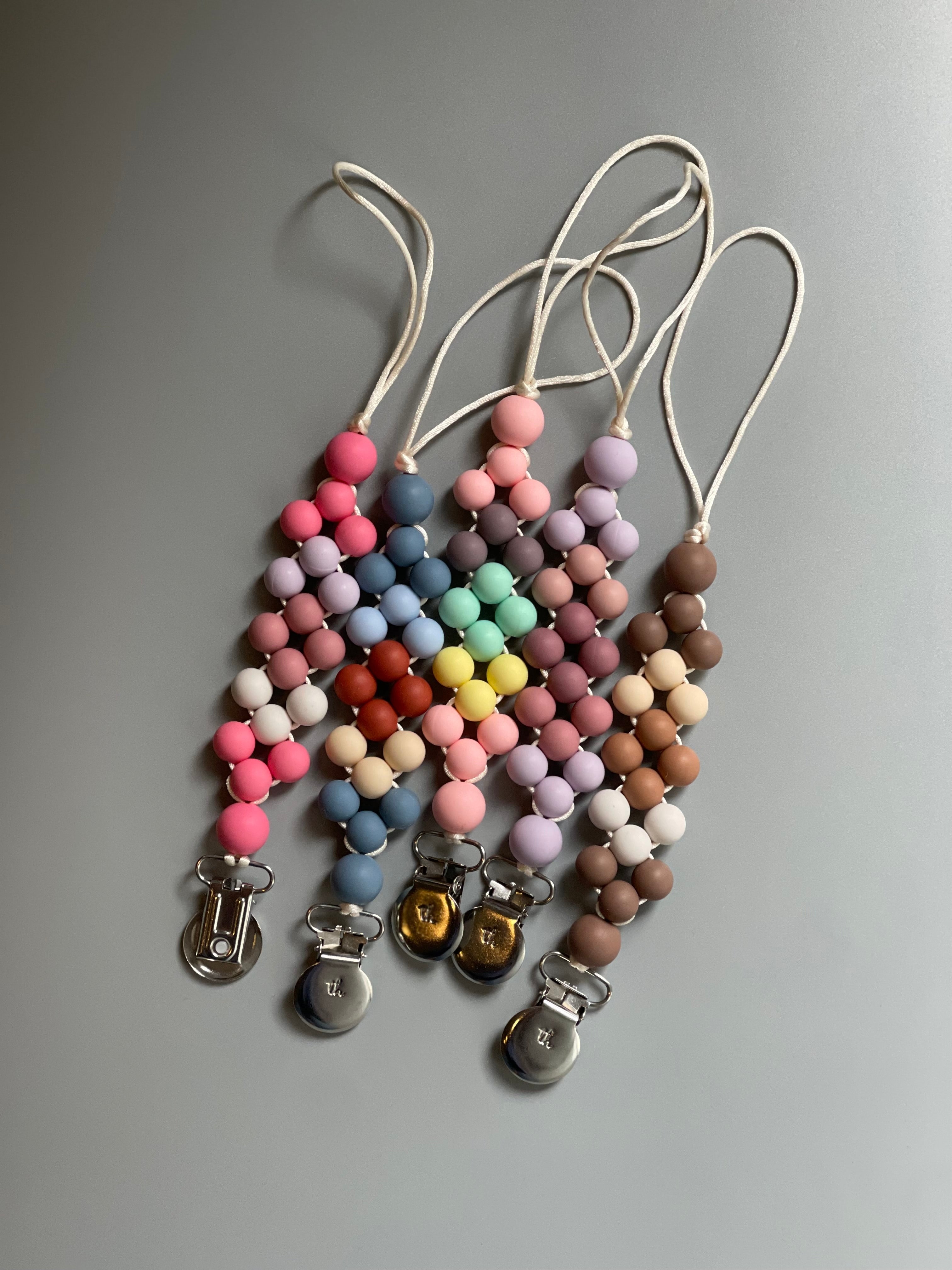 Colorful beaded keychains with clips on a gray background