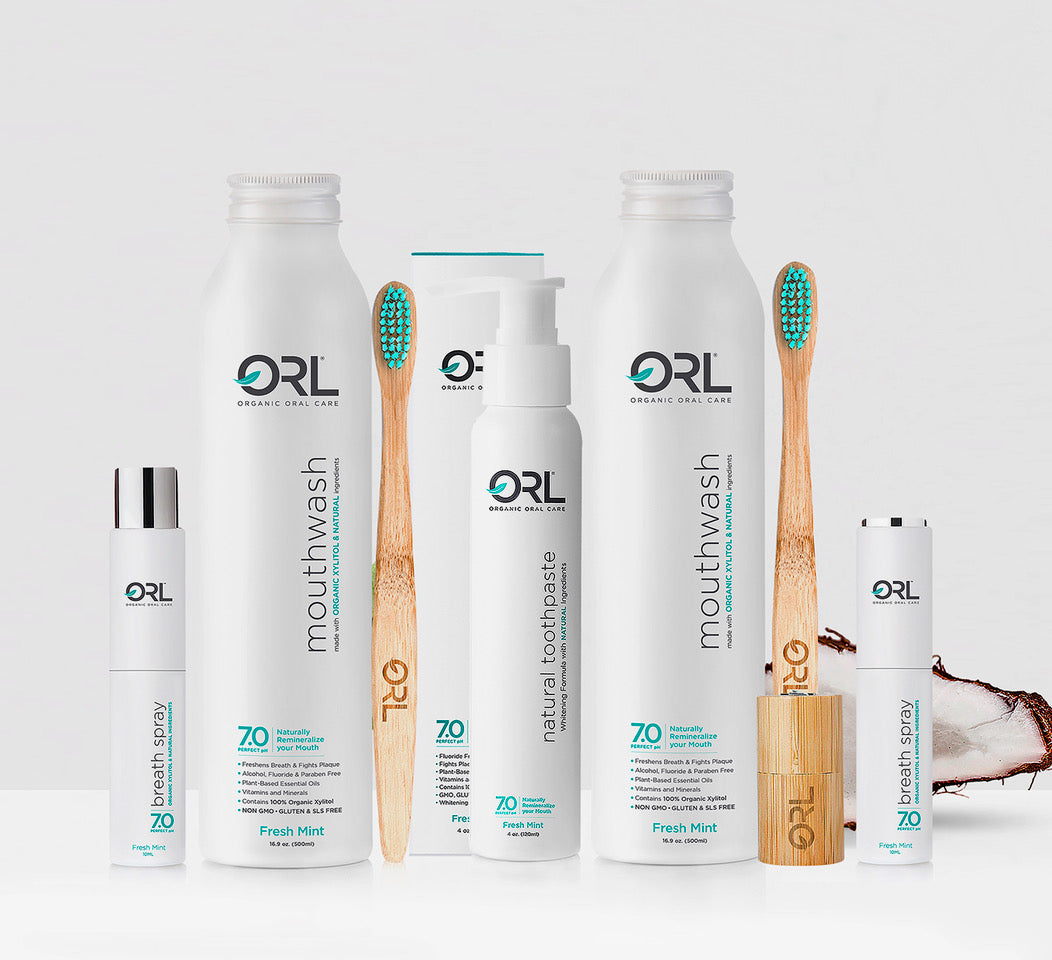ORL Organic Oral Care products including mouthwash, toothpaste, and a wooden toothbrush on a white background.