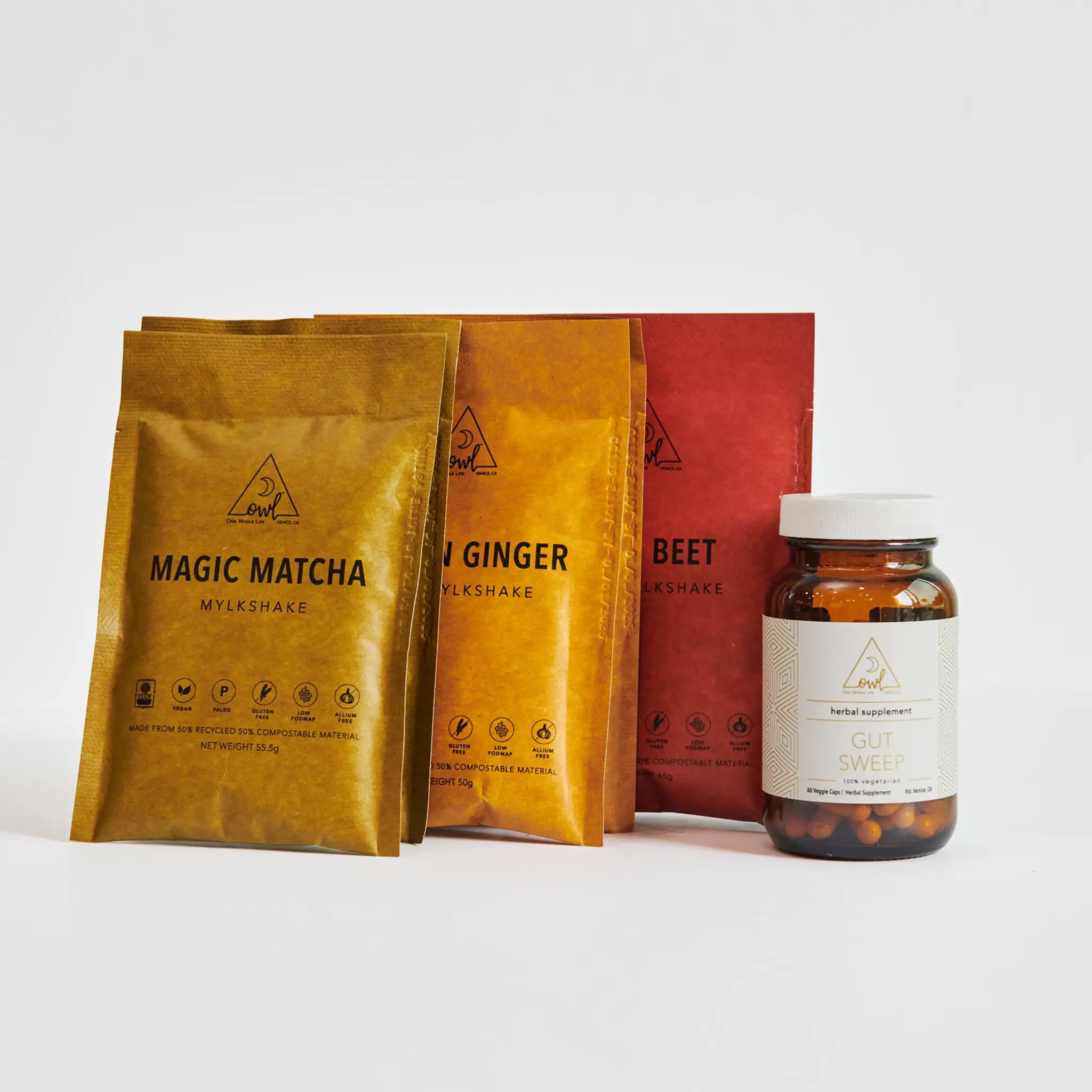 Three packages labeled 'Magic Matcha', 'Ginger', and 'Beet' next to a bottle labeled 'Gulb Sweed' on a white background.
