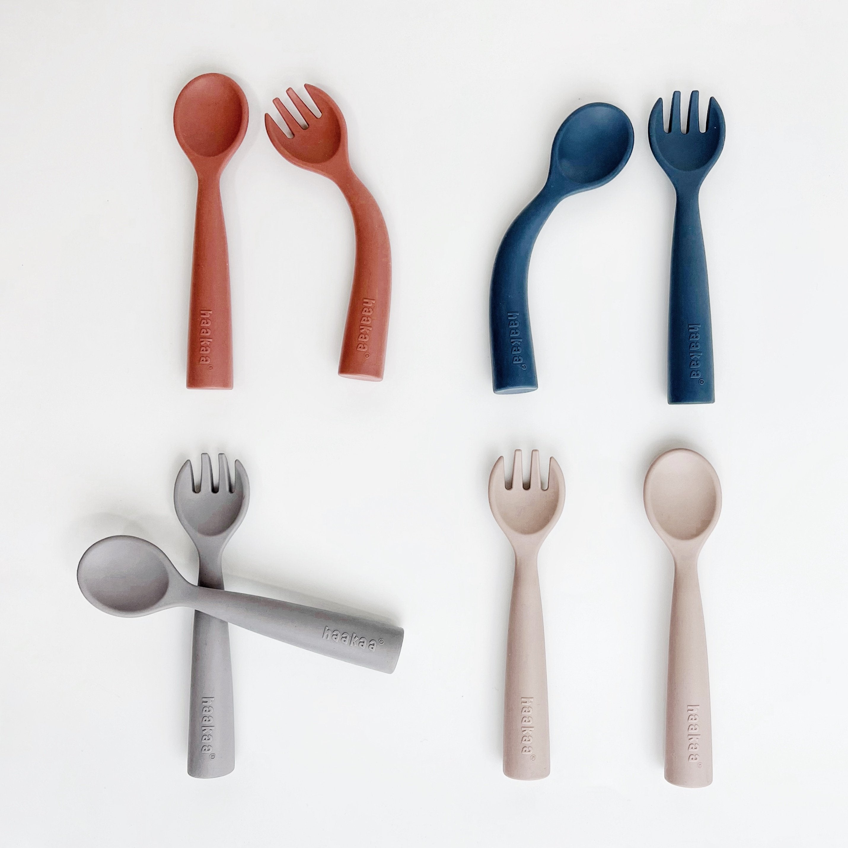 Set of colorful children's cutlery including spoons and forks on a white background