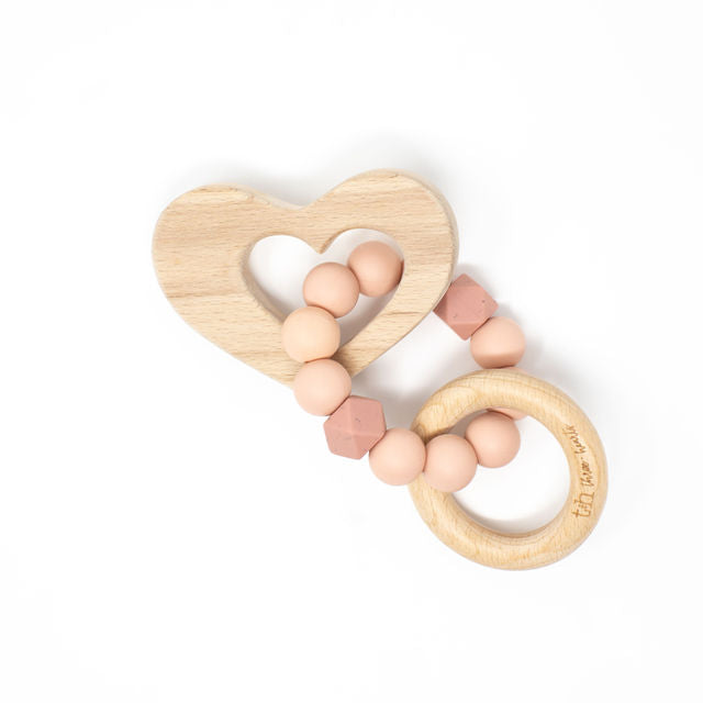 Wooden heart-shaped teething ring with pink beads on a white background