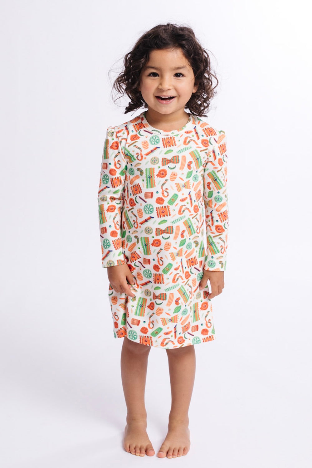 Child wearing a colorful patterned nightshirt on a white background