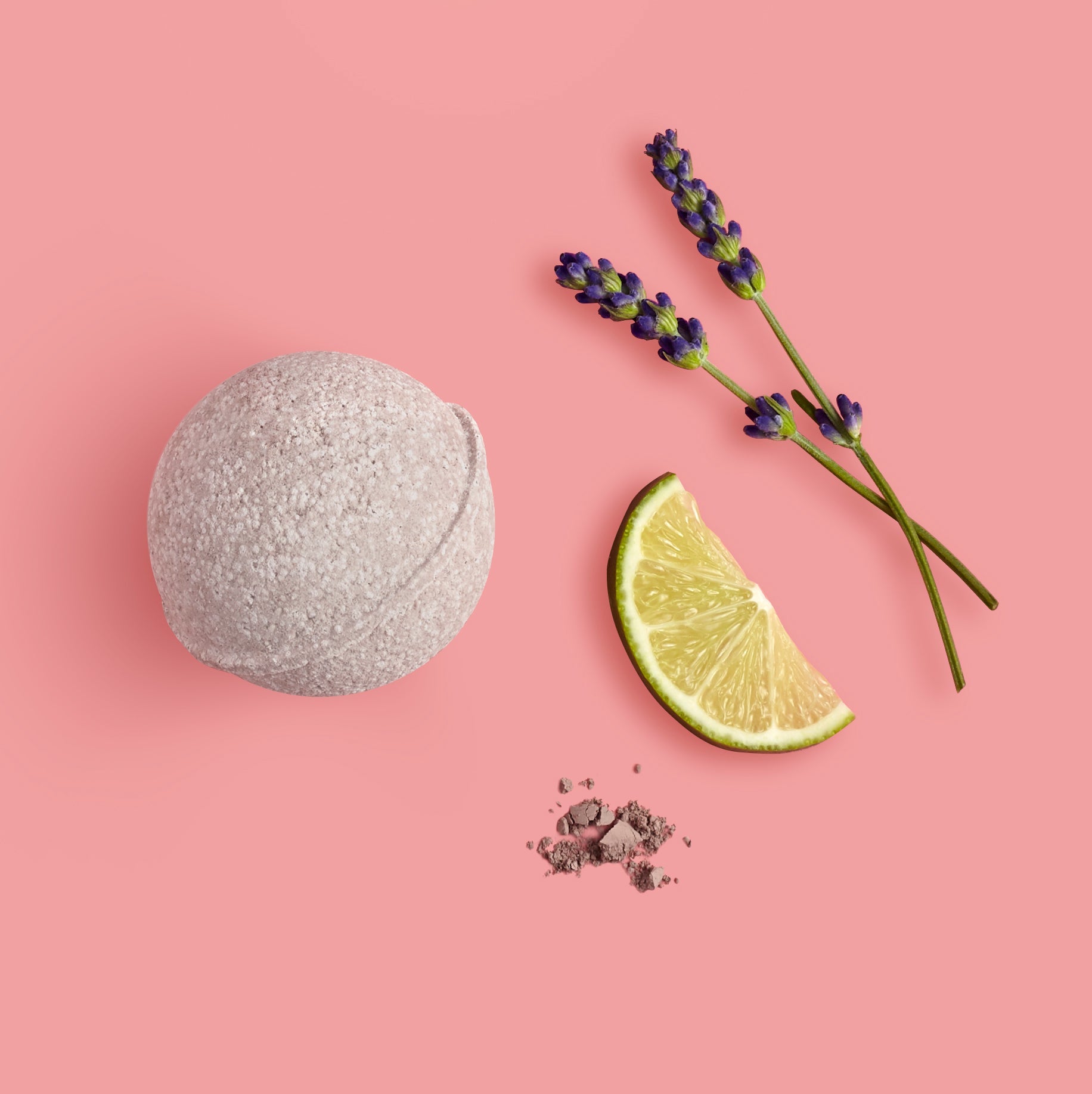 Bath bomb, lime wedge, and lavender on a pink background