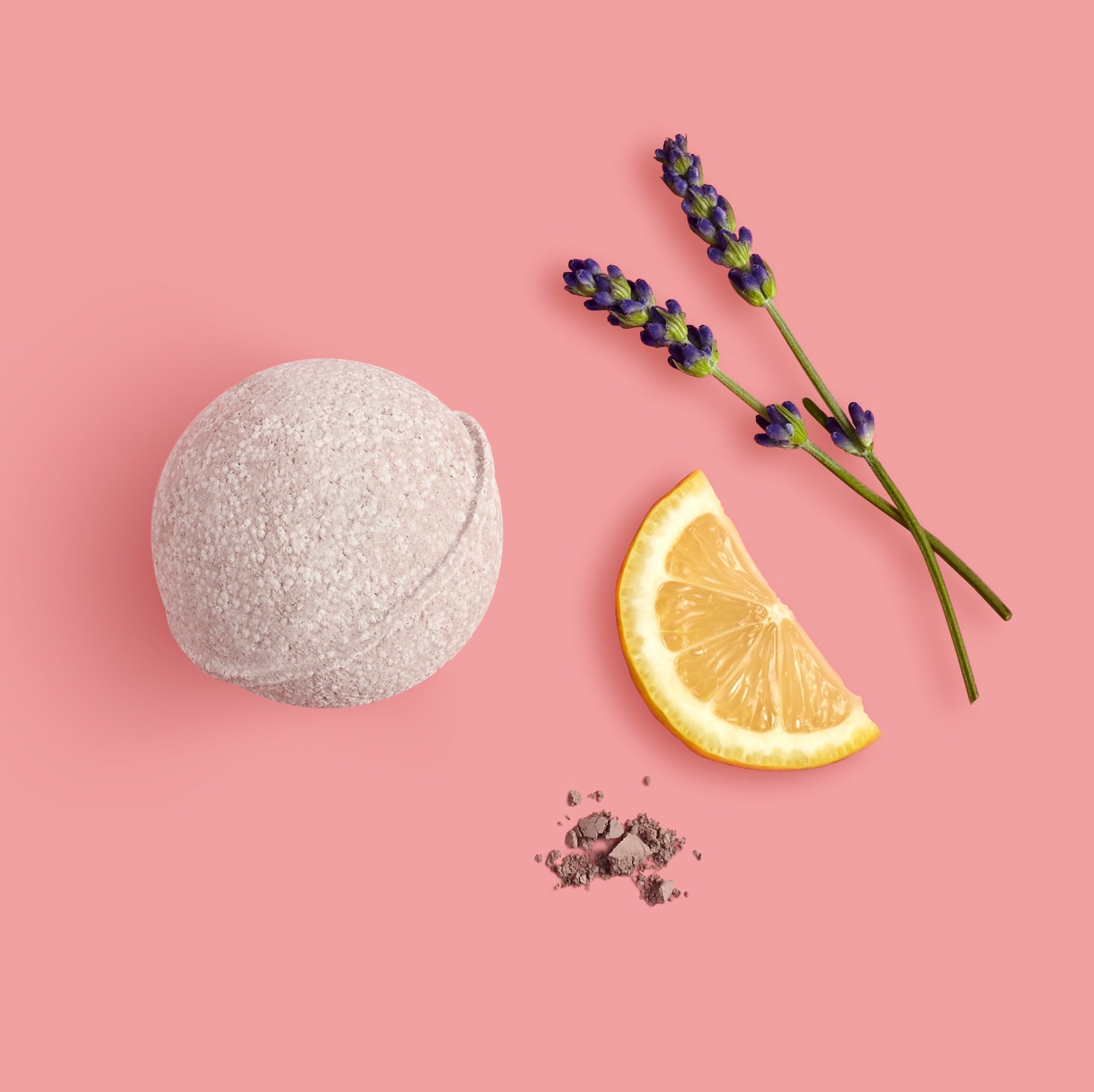 Bath bomb, lemon slice, and lavender on a pink background