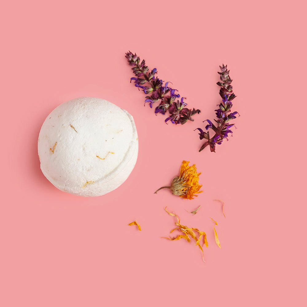 Bath bomb with dried flowers on a pink background