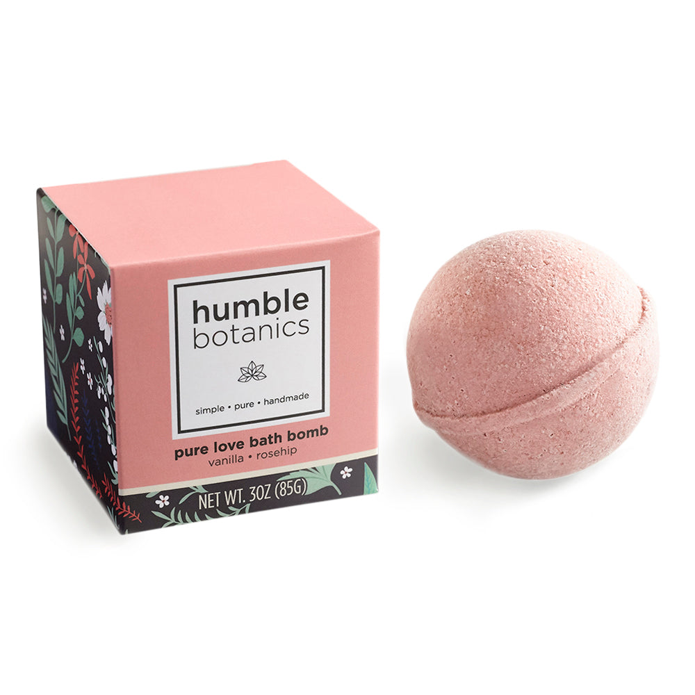 Pink bath bomb with 'humble botanics' packaging on a white background