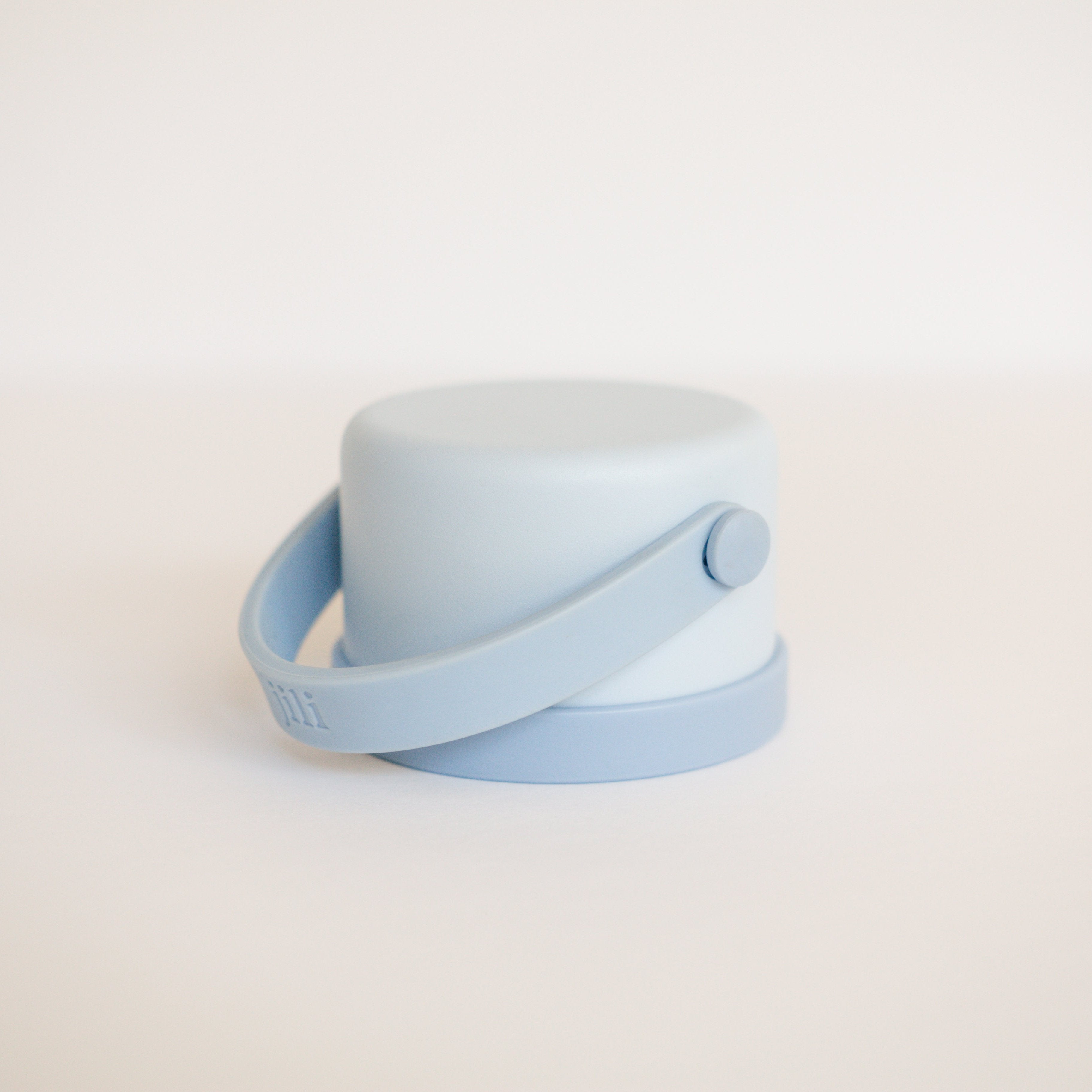 Light blue container with a strap on a beige background