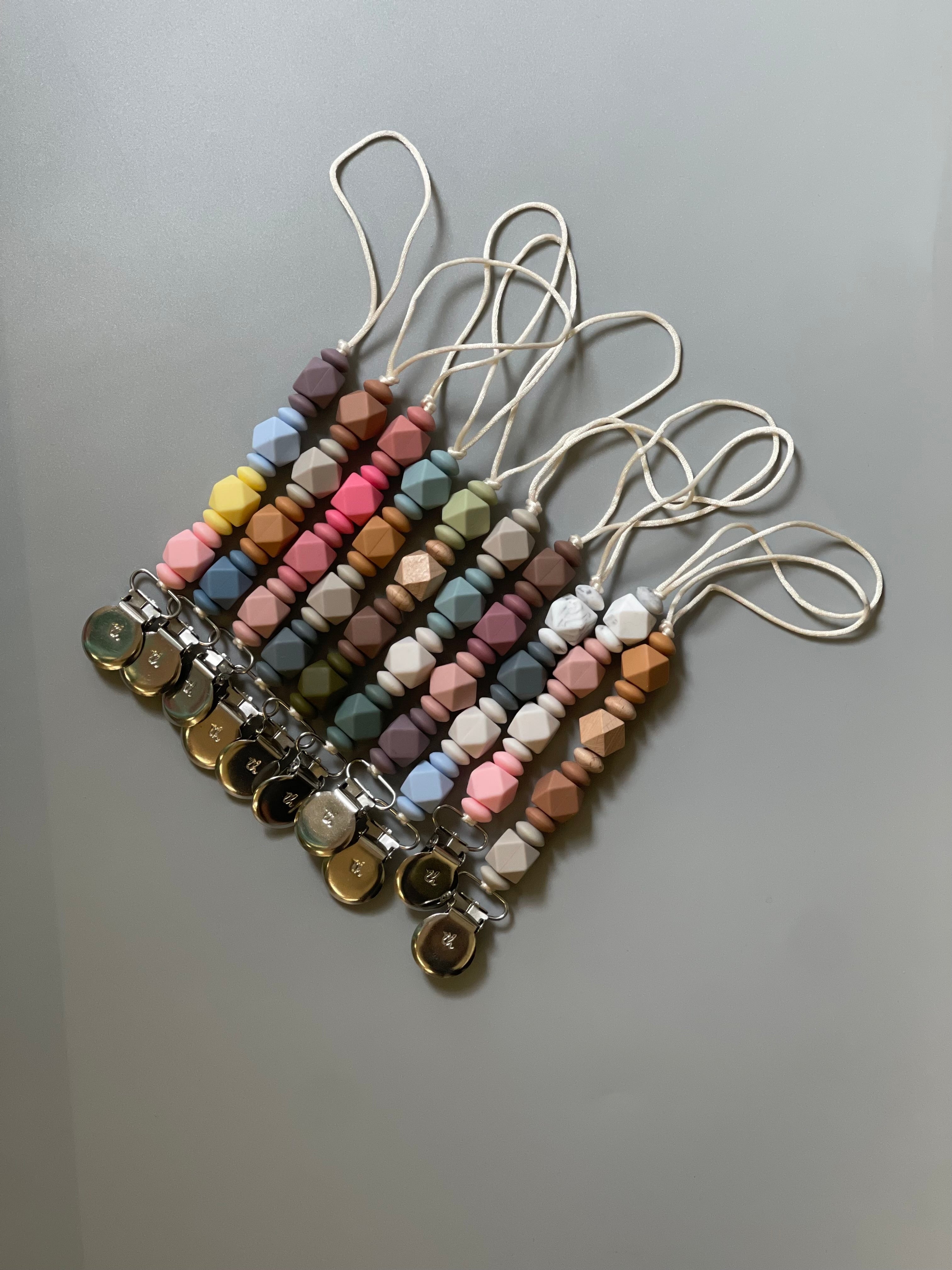 Set of colorful beaded keychains on a gray background