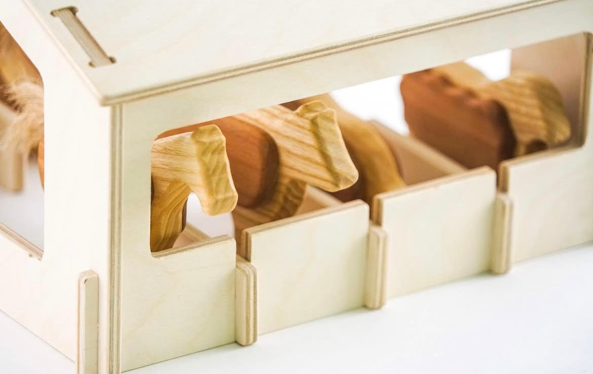 Wooden horse figures in a display case on a white background