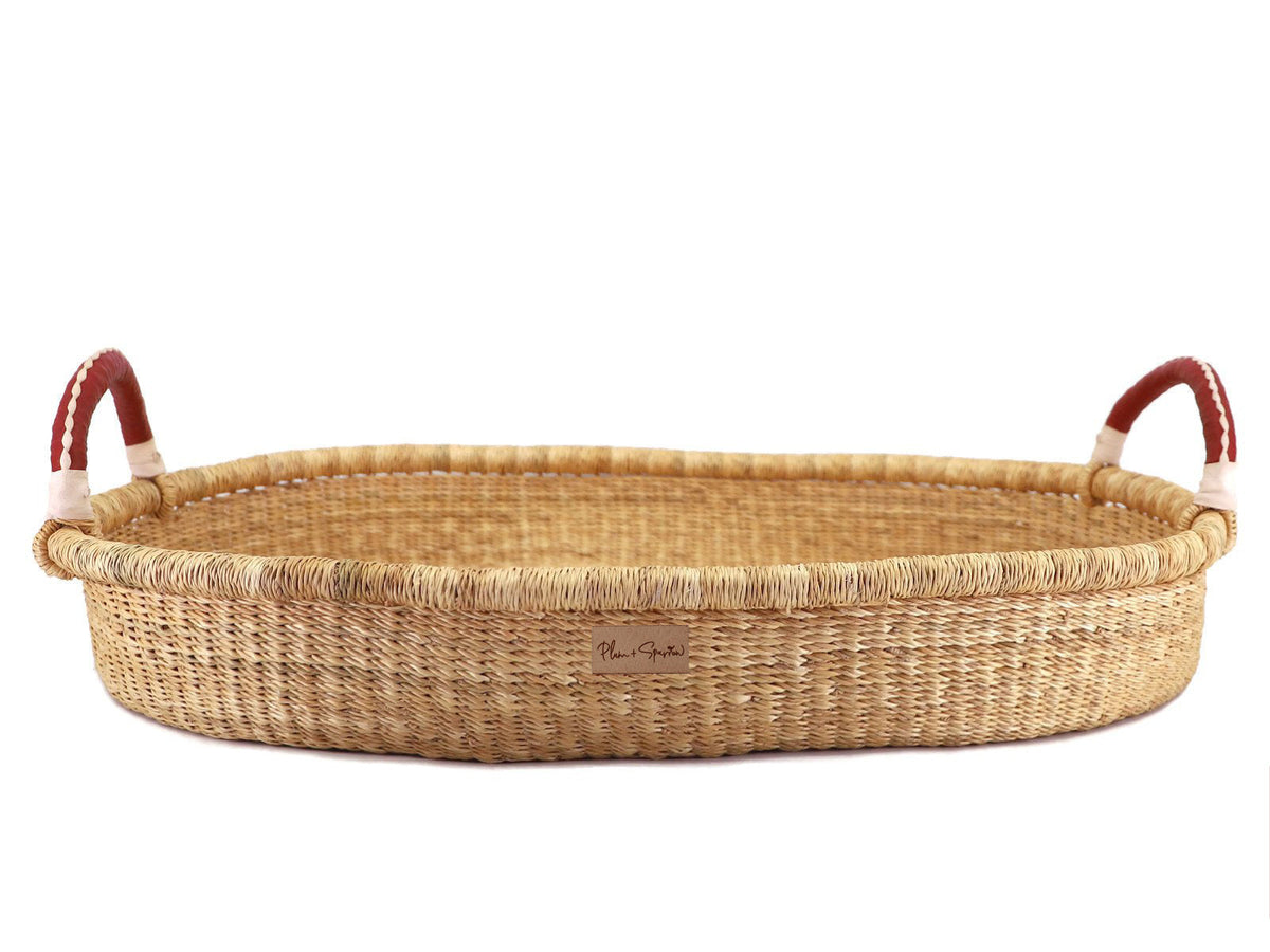 Wicker baby basket with red handles on a white background