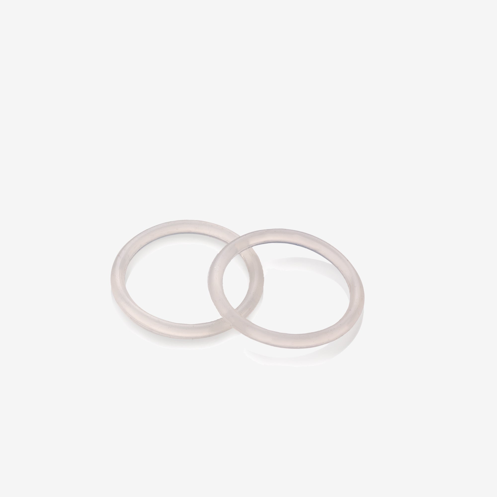 Two white rubber washers on a light gray background