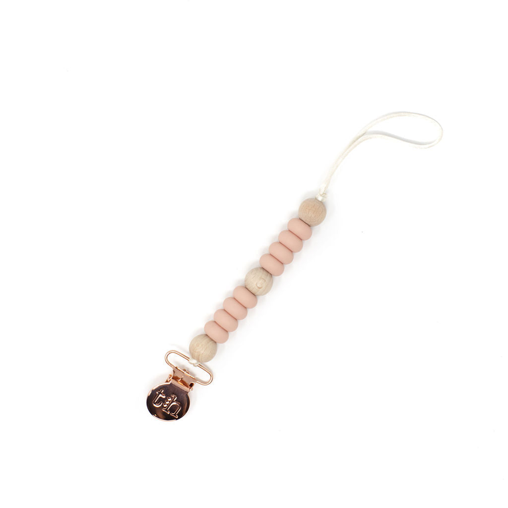 Pacifier clip with pink and beige beads on a white background