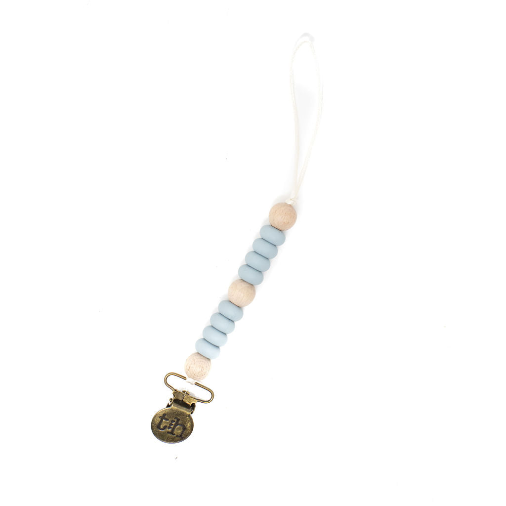Beaded pacifier clip with a gold charm on a white background
