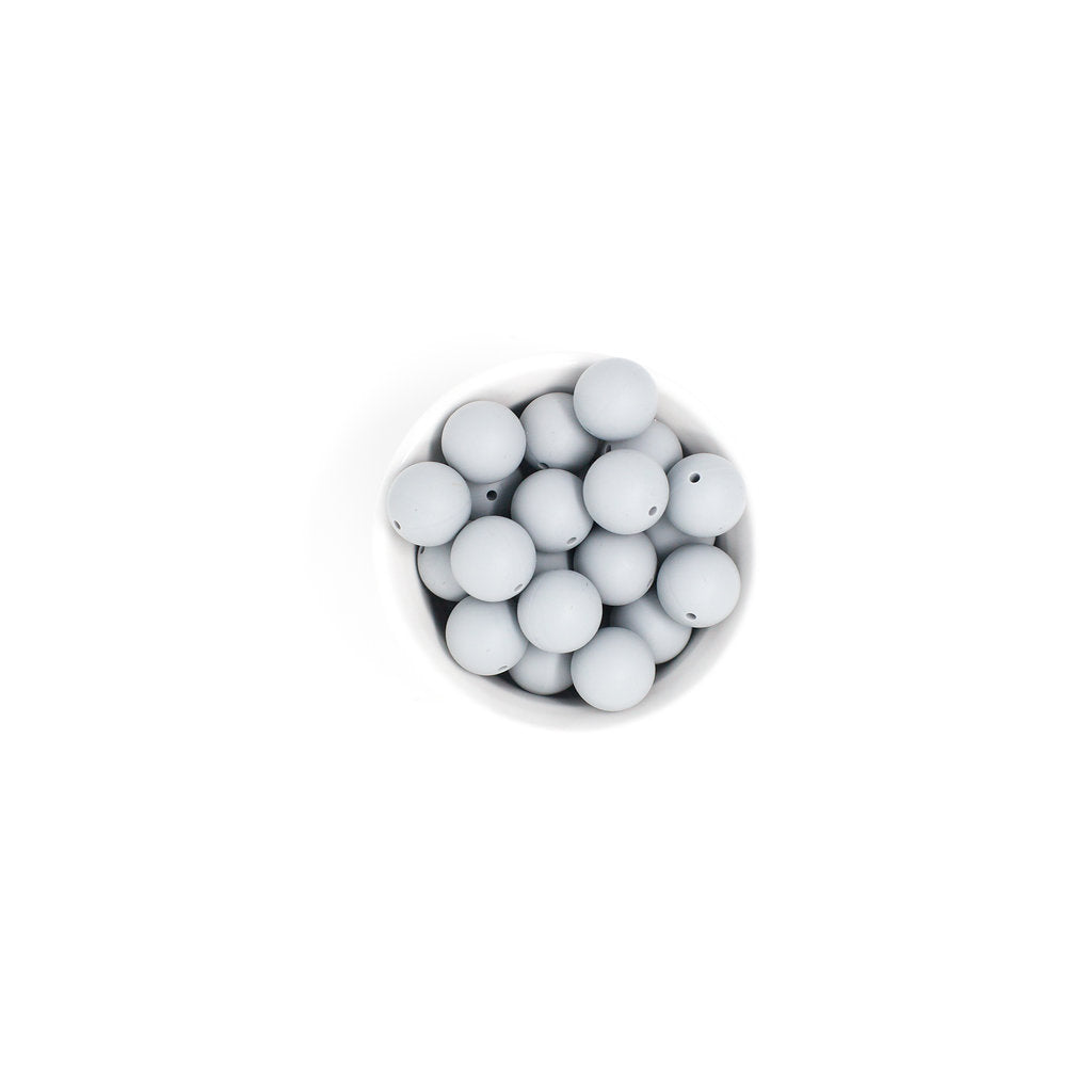 White spherical beads in a small white bowl on a white background