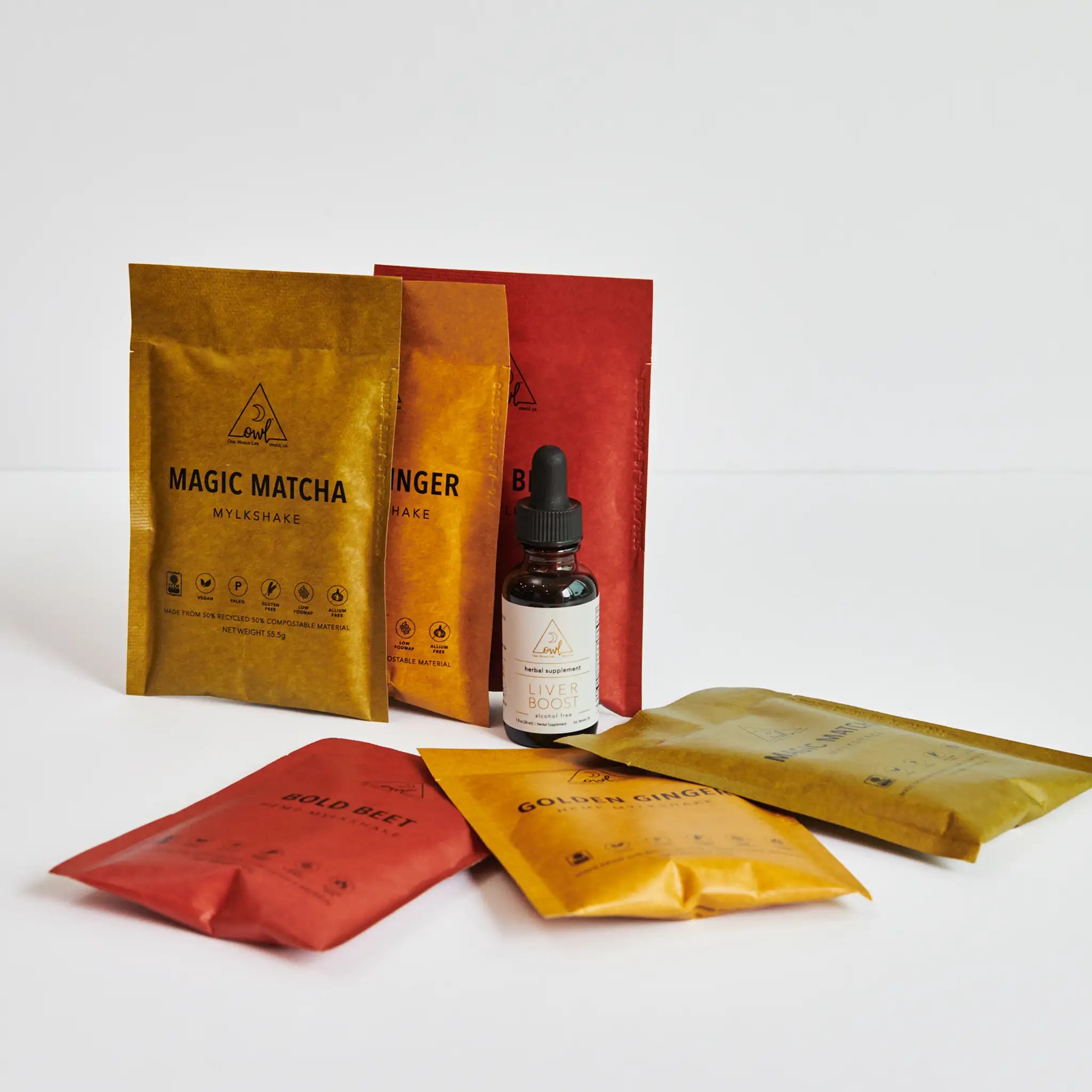 Assorted health and wellness products including packets and a bottle on a white background