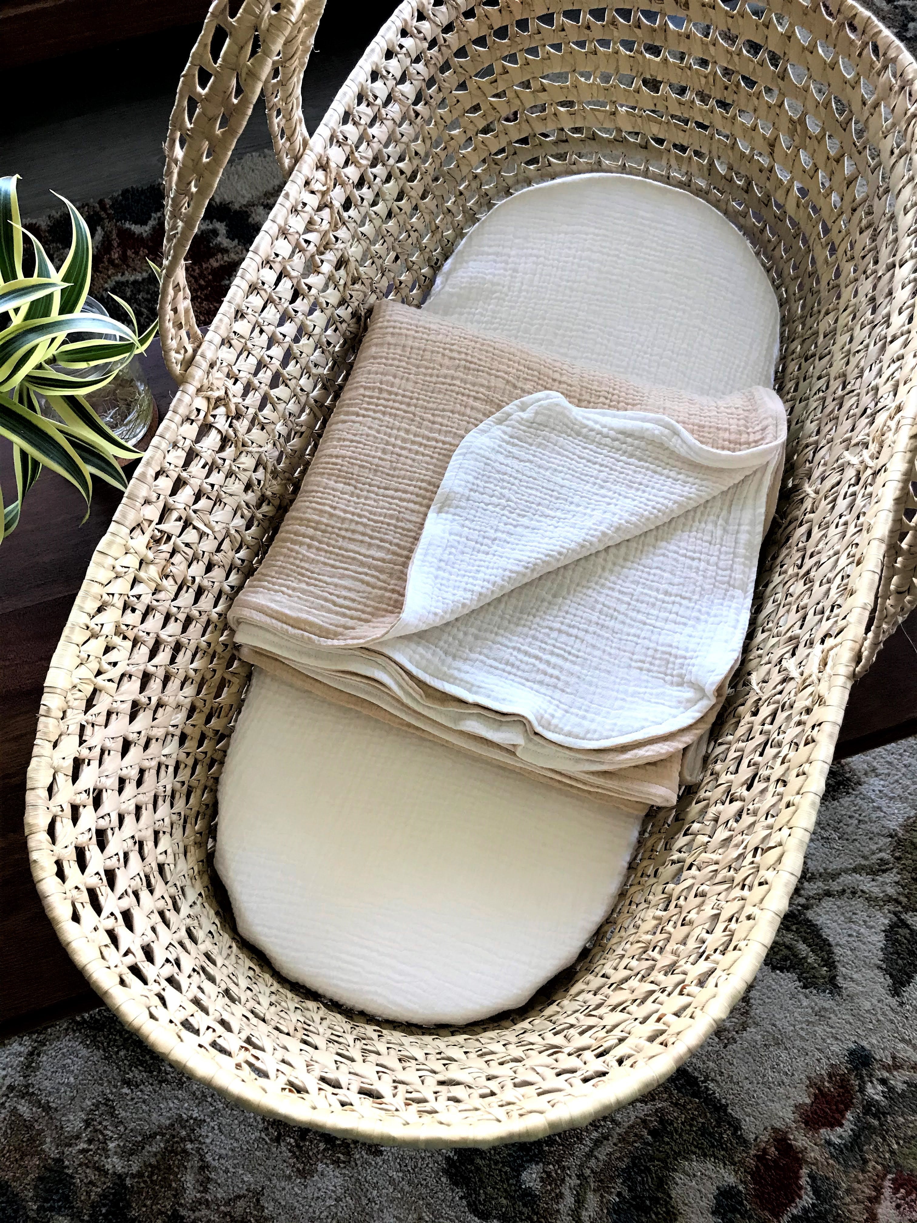 Woven basket with white and beige fabric inside on a textured surface.