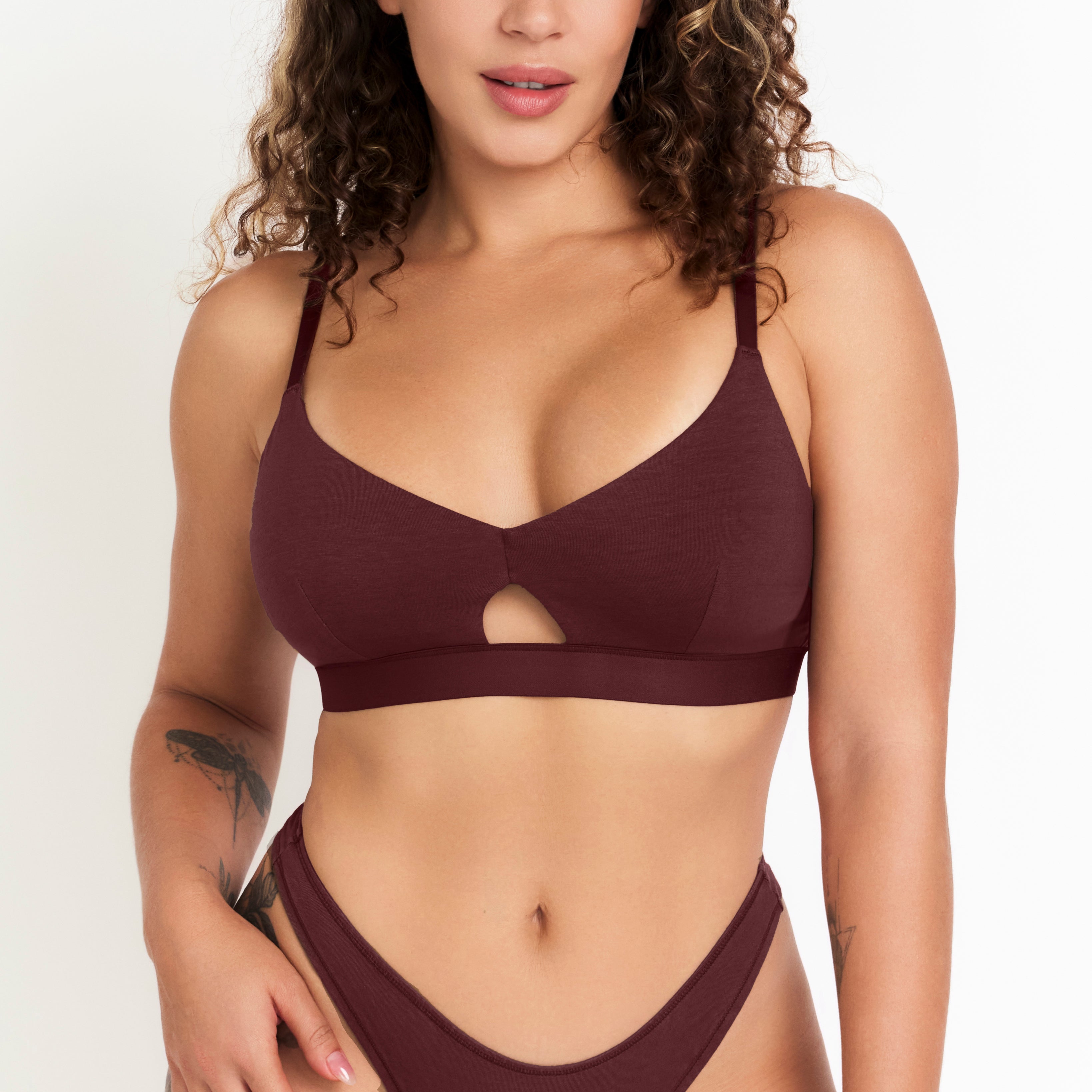 Woman wearing a maroon bikini set on a plain background