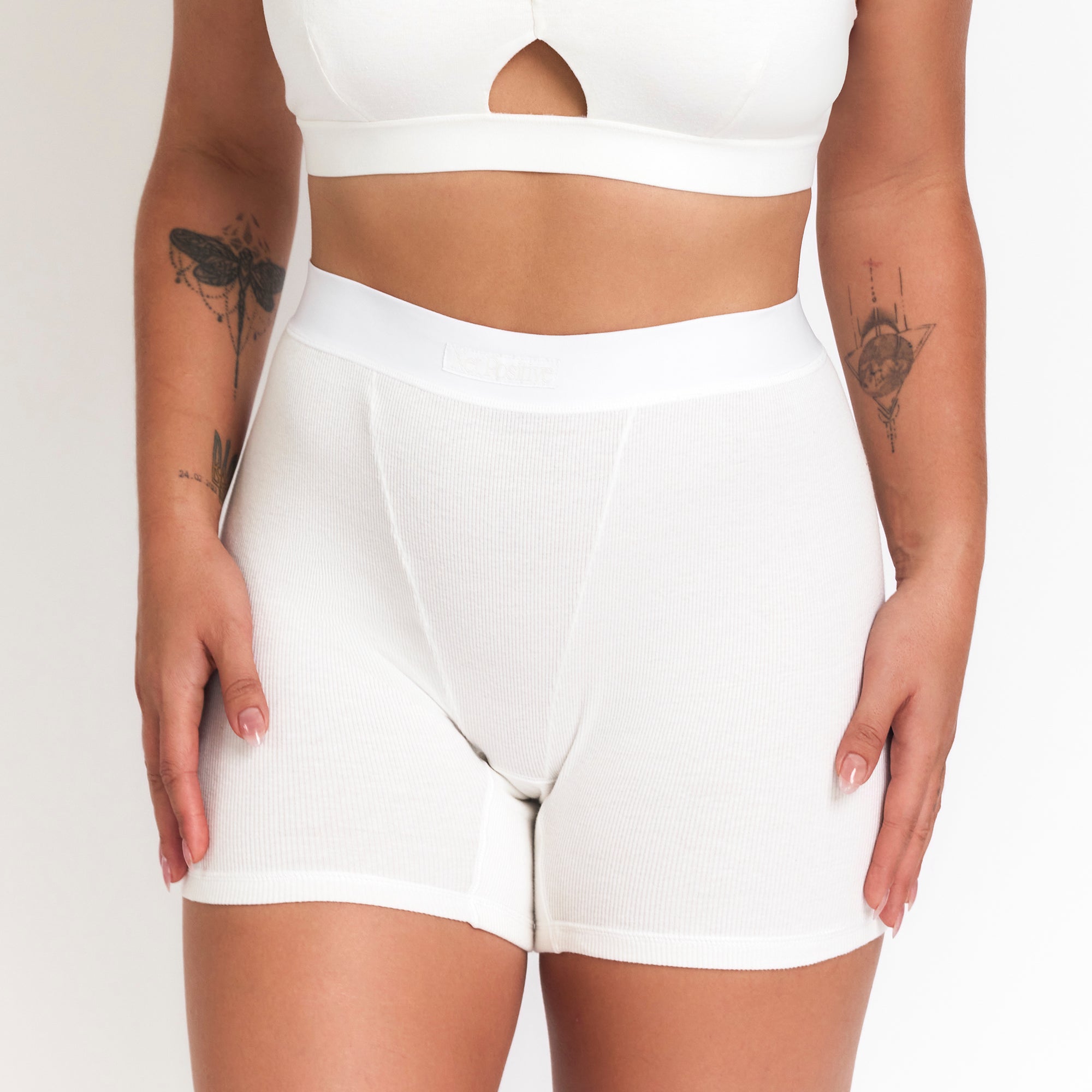 Person wearing white shorts on a plain background