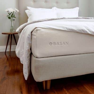 Bed with OBASAN mattress and bedding in a room setting