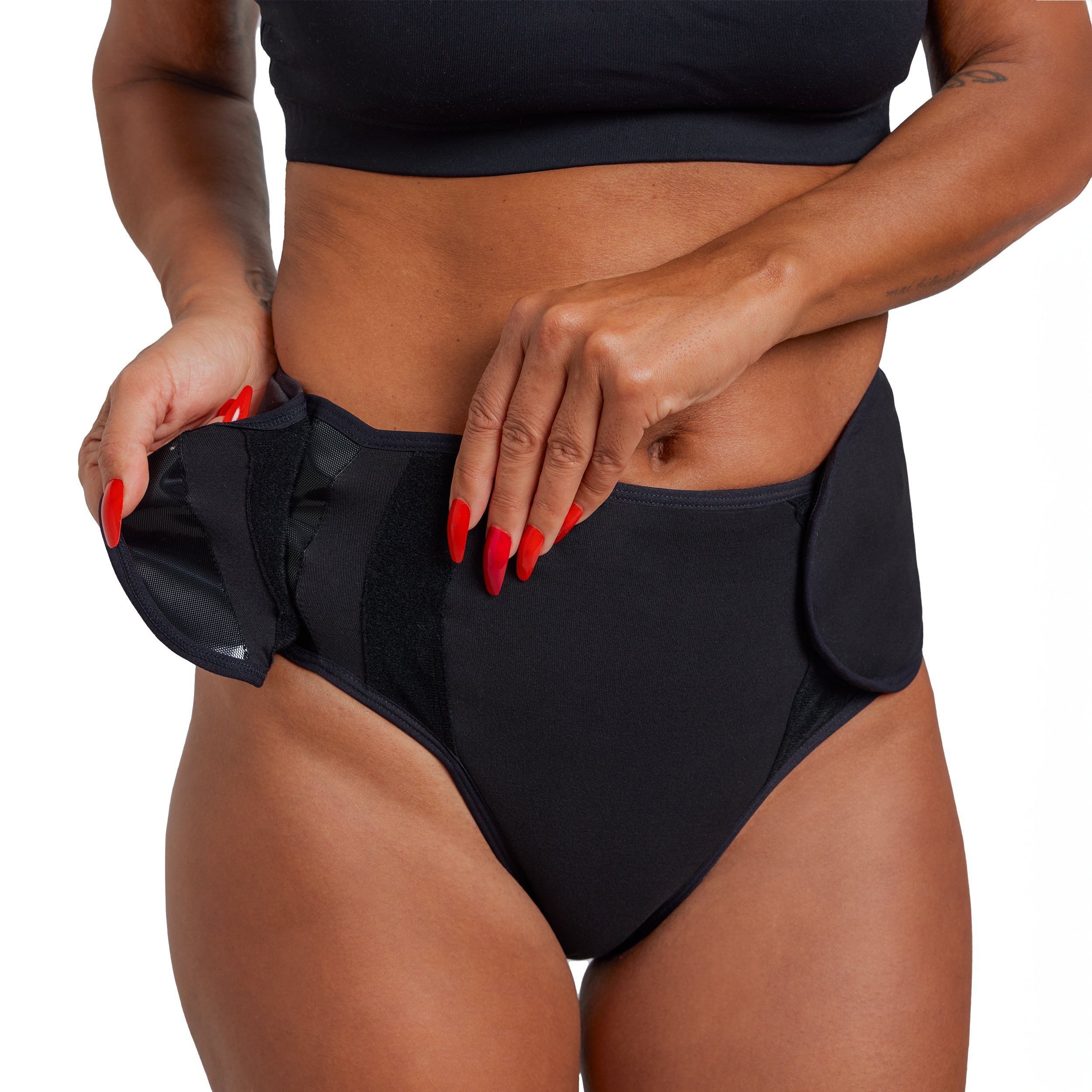 Person wearing black high-waisted bikini bottoms with a plain background