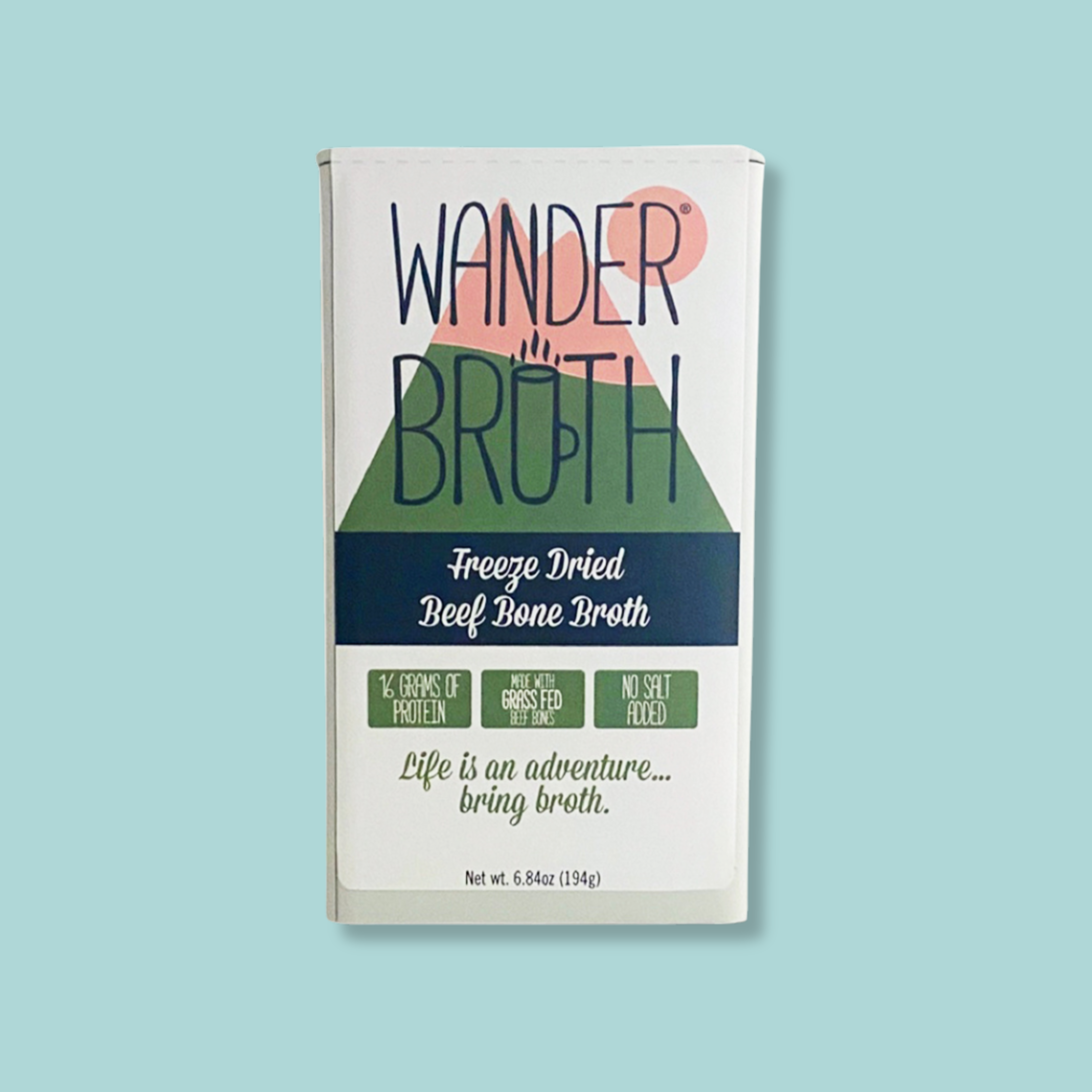 A package of Wander Breath Freeze Dried Beef Bone Broth, featuring a white box with a green mountain graphic, navy blue text, and a pink sun, set against a solid light blue background.