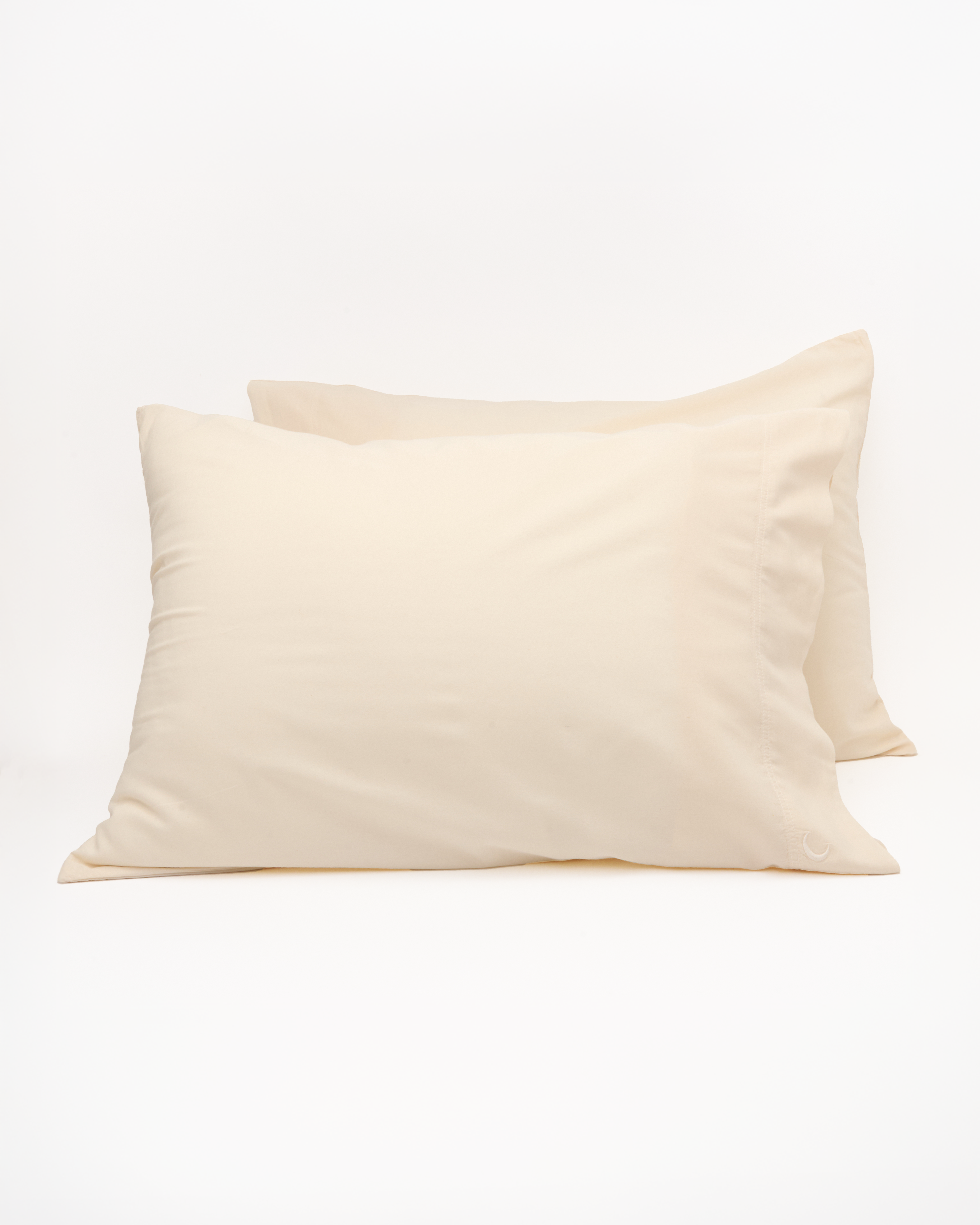 Two beige pillowcases on a white background