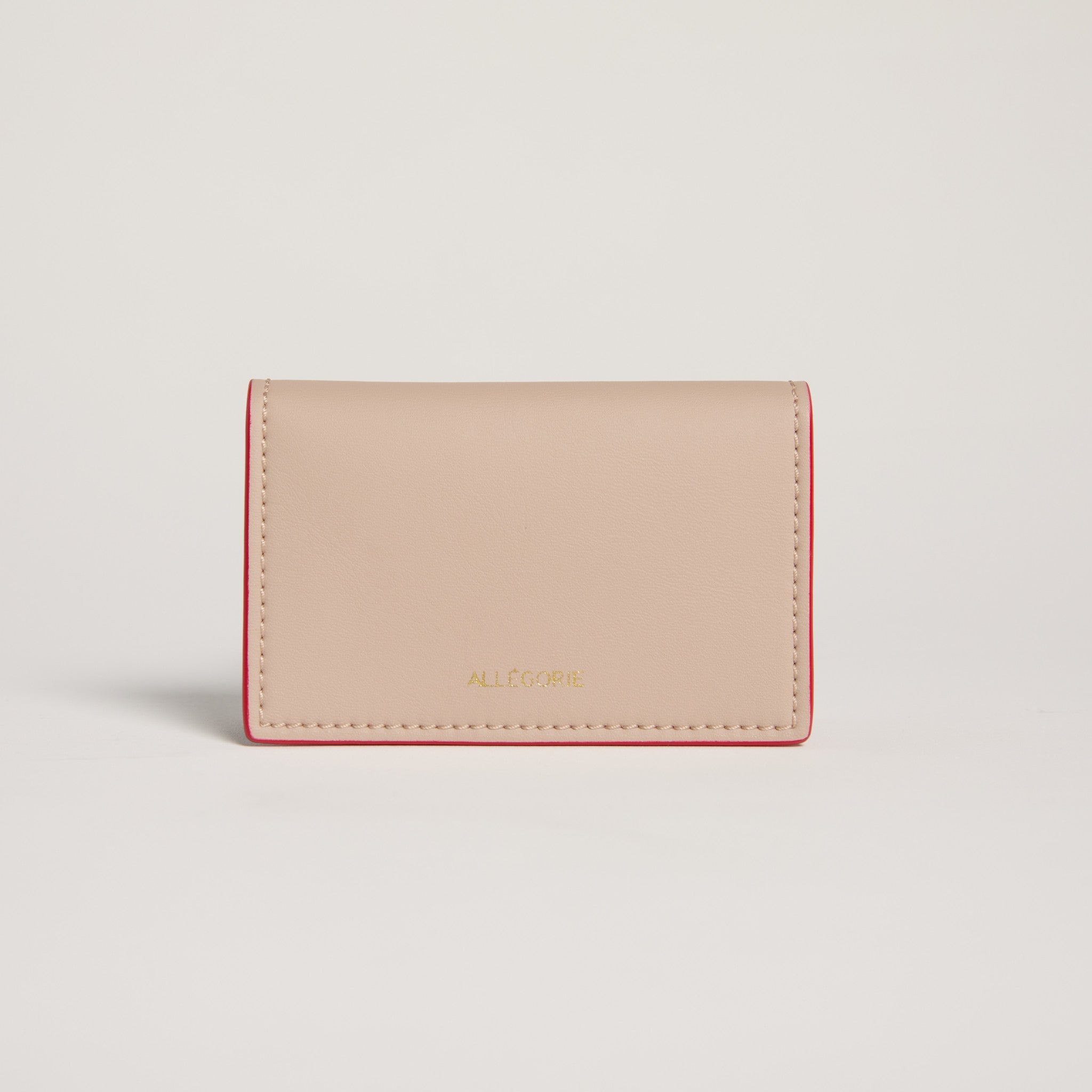 Beige wallet with red stitching on a light gray background