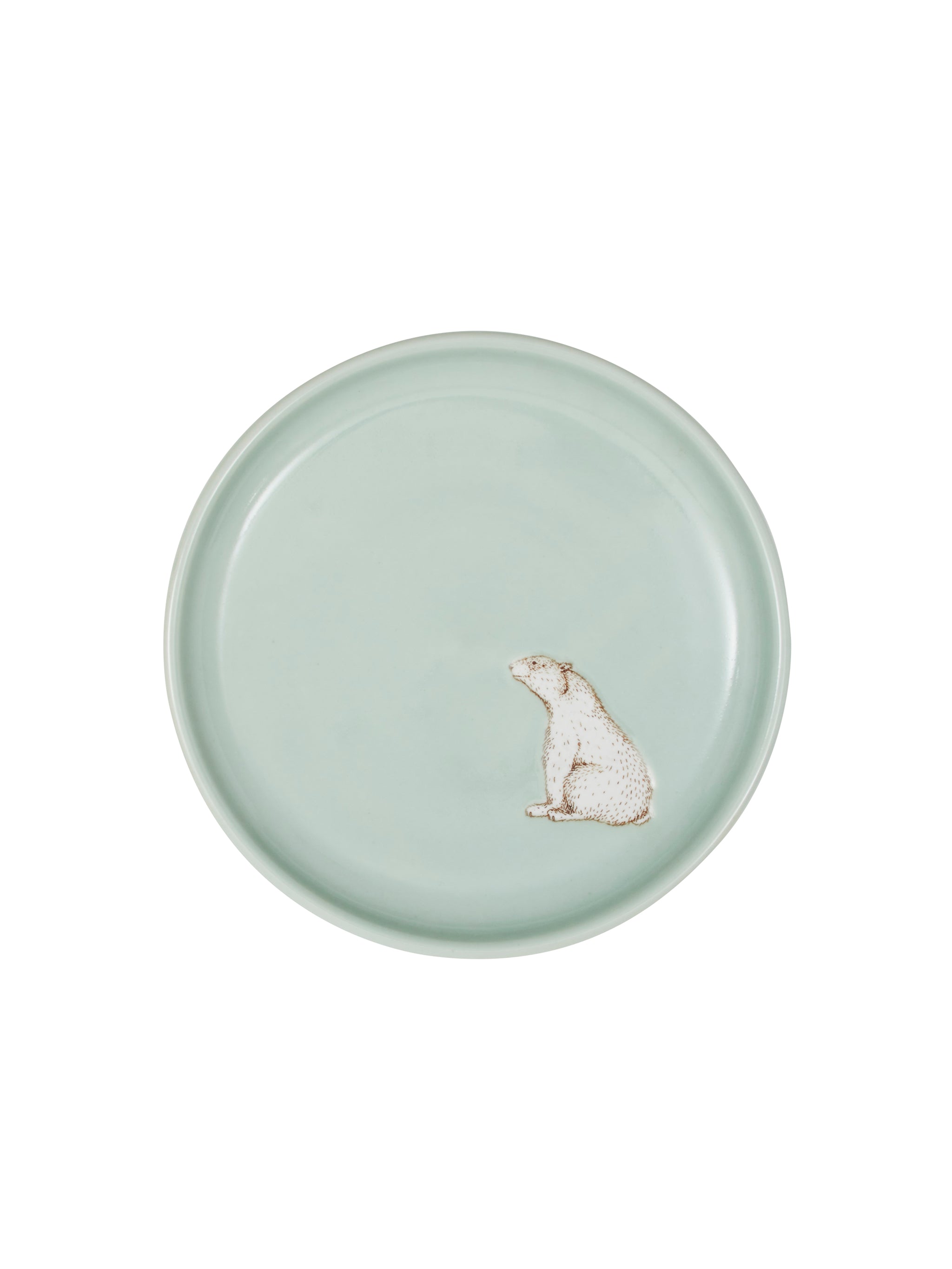Round ceramic plate with a polar bear design on a light green background