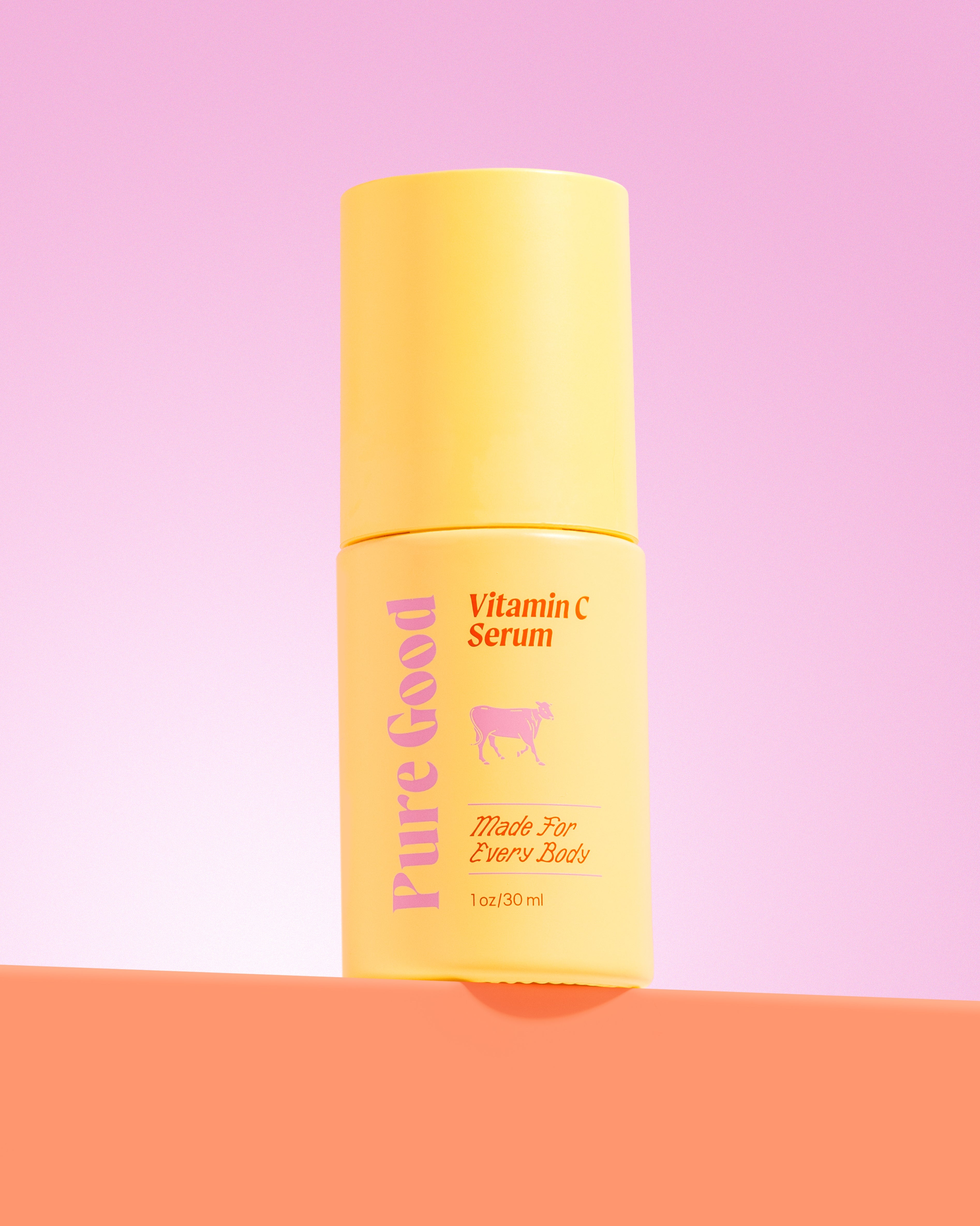Yellow bottle of Vitamin C Serum with 'Pure Good' branding on a pink and orange gradient background