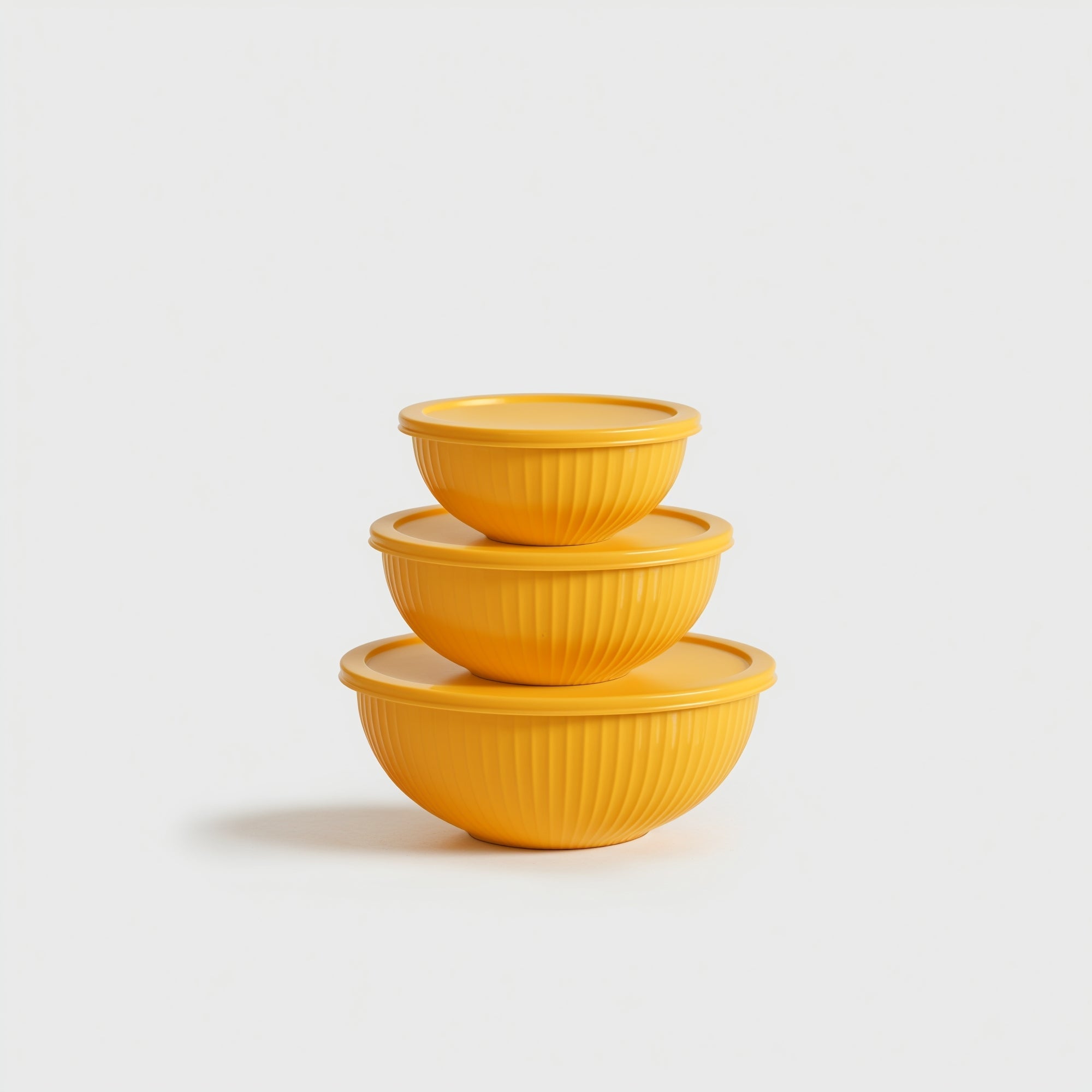 Set of three yellow ceramic bowls stacked on a light gray background