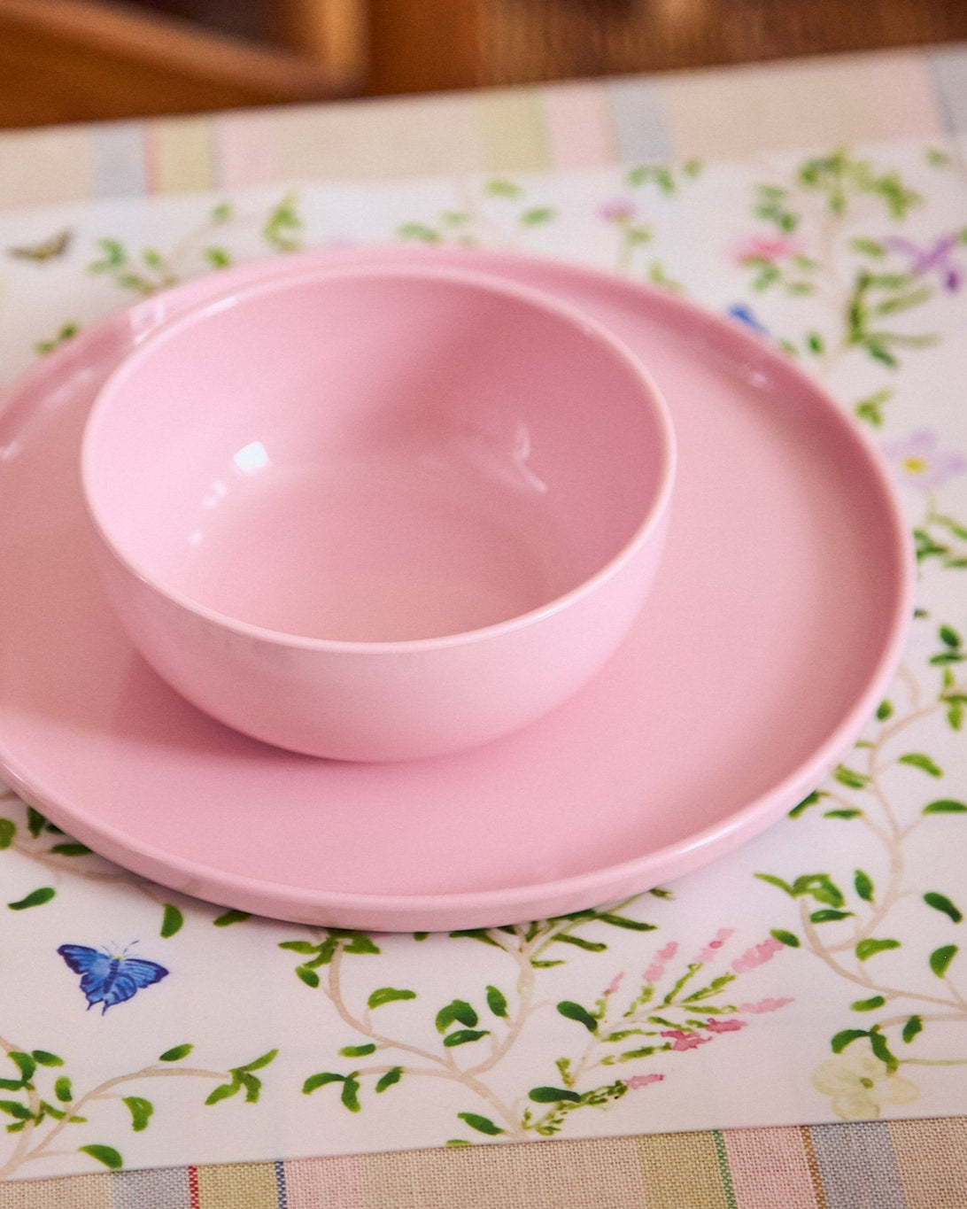 Pink bowl and plate set on a floral placemat