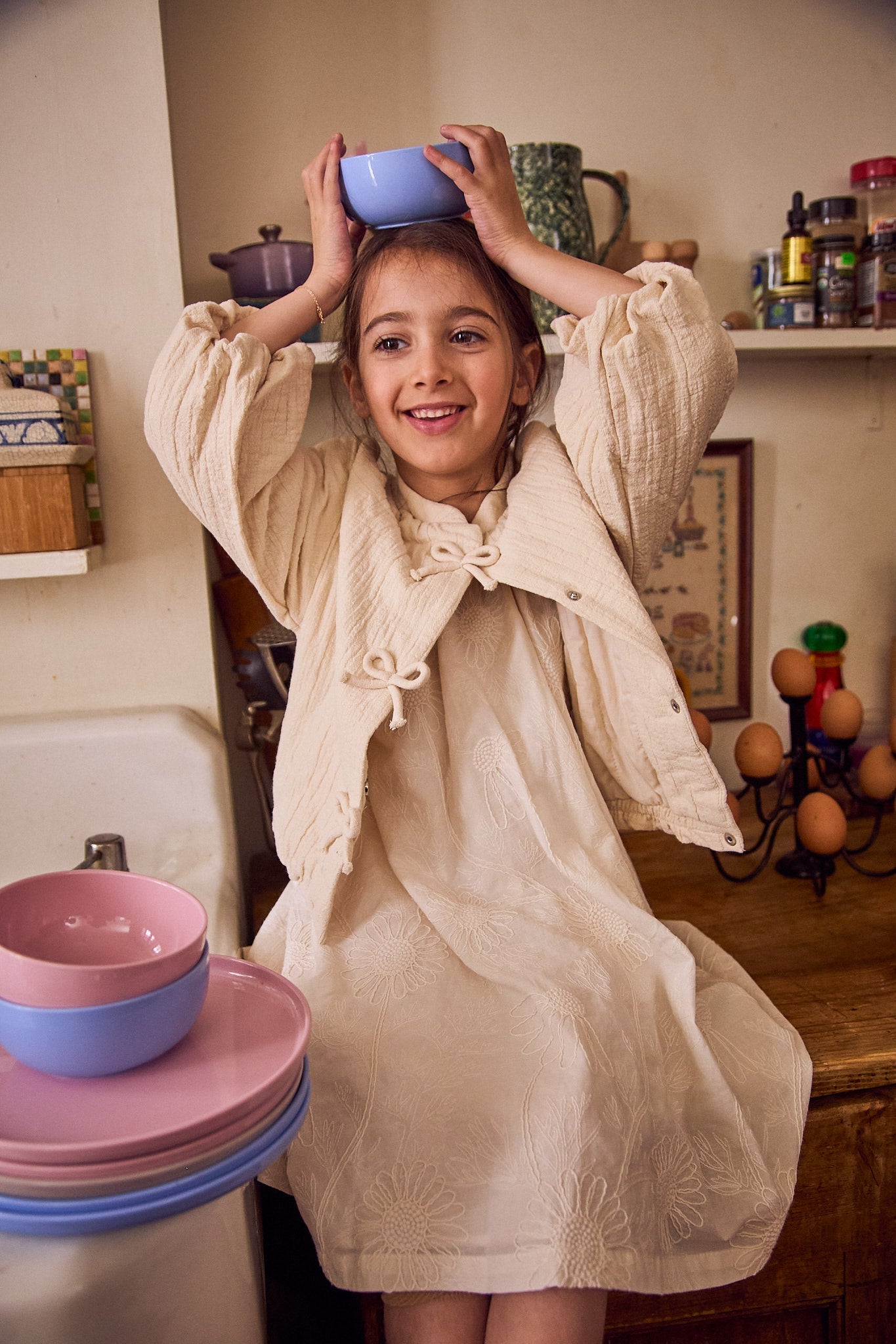 Young girl playing with colorful bowls in a kitchen