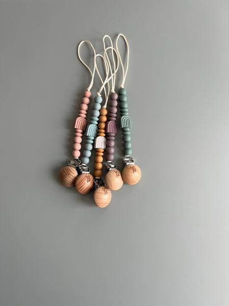 Set of colorful beaded keychains on a gray background