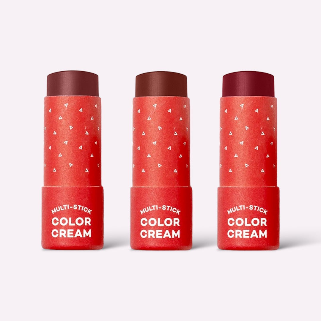 Three red containers of Multi-Stick Color Cream on a white background
