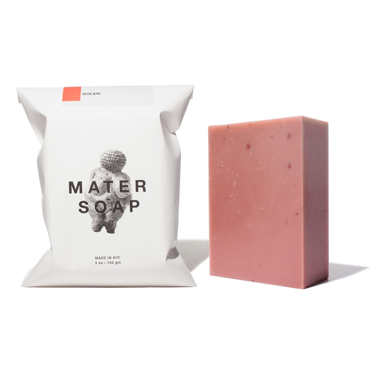 Pink soap bar next to its packaging on a white background