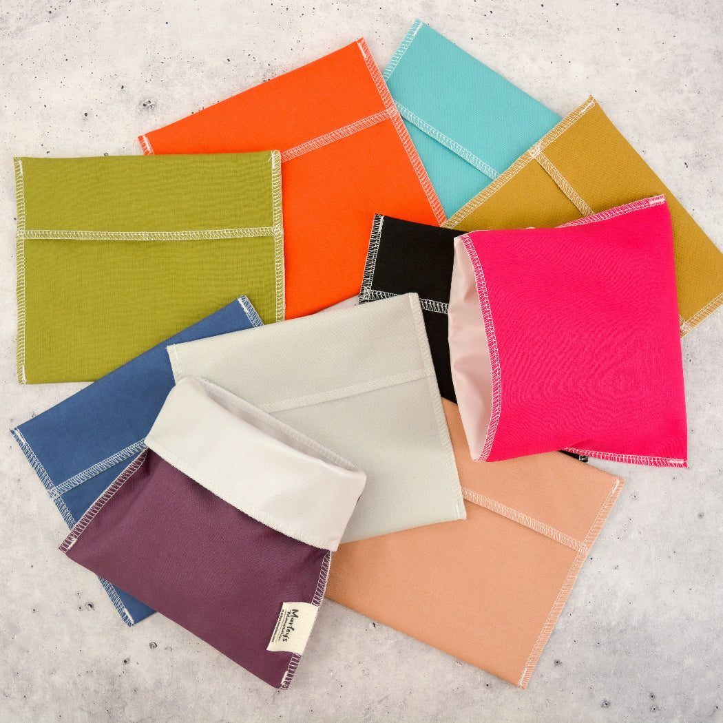 Colorful fabric envelopes on a textured surface