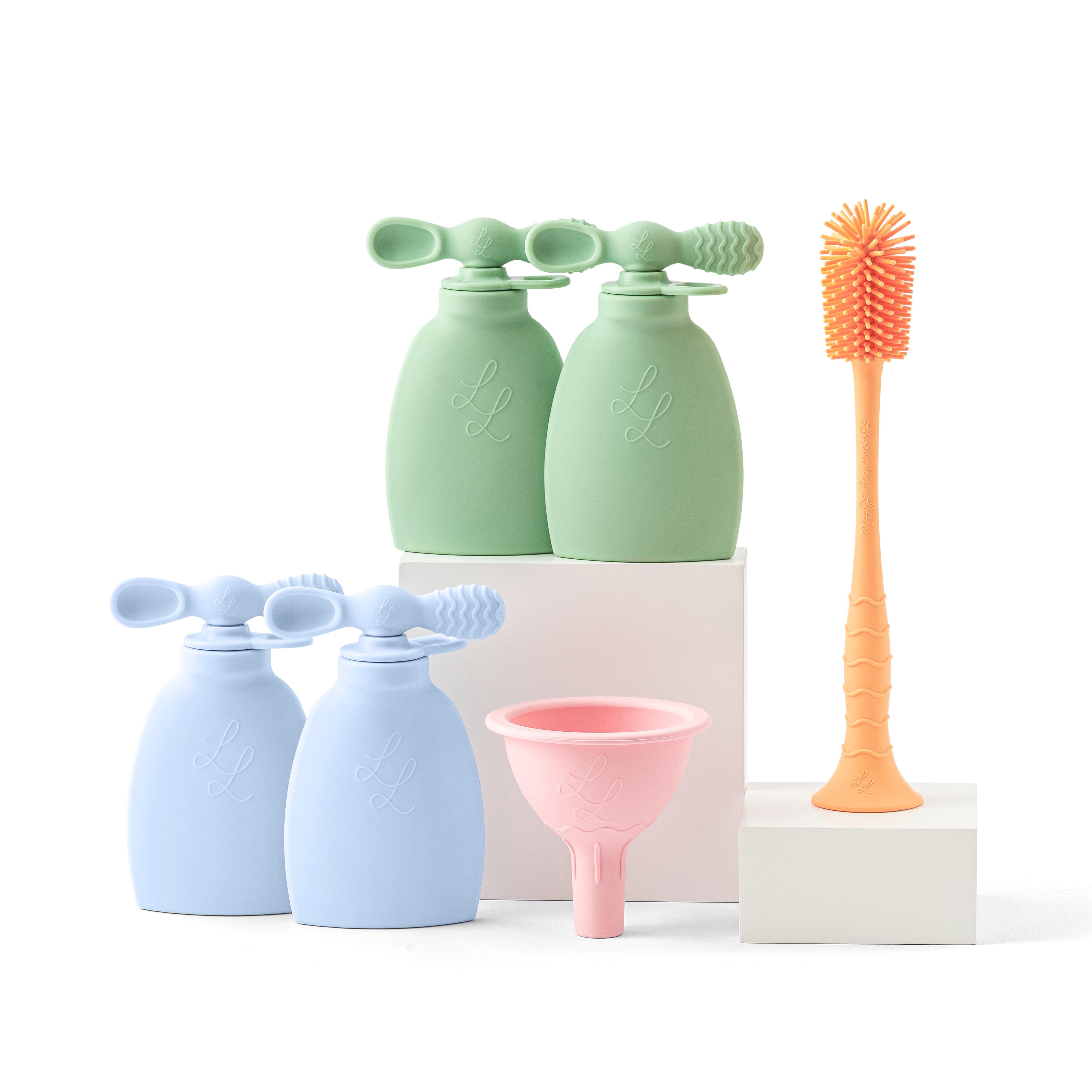 Set of cleaning tools including green and blue bottles with sponges, a pink funnel, and an orange brush on a white background.