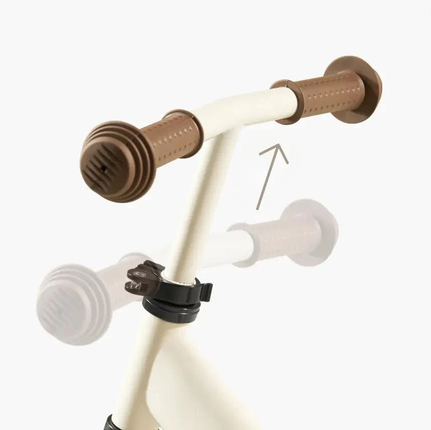 Children's bike handlebar with brown grips and white accents on a white background