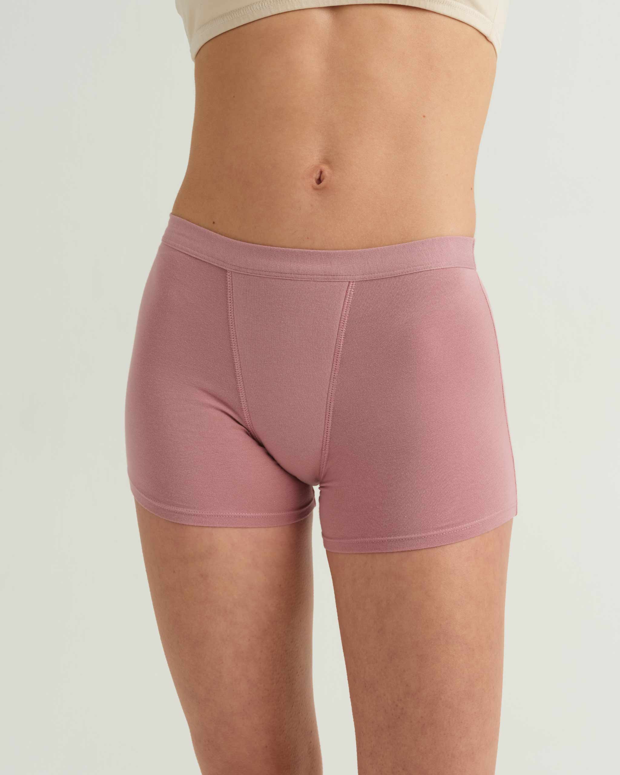 Person wearing pink boxer briefs on a plain background