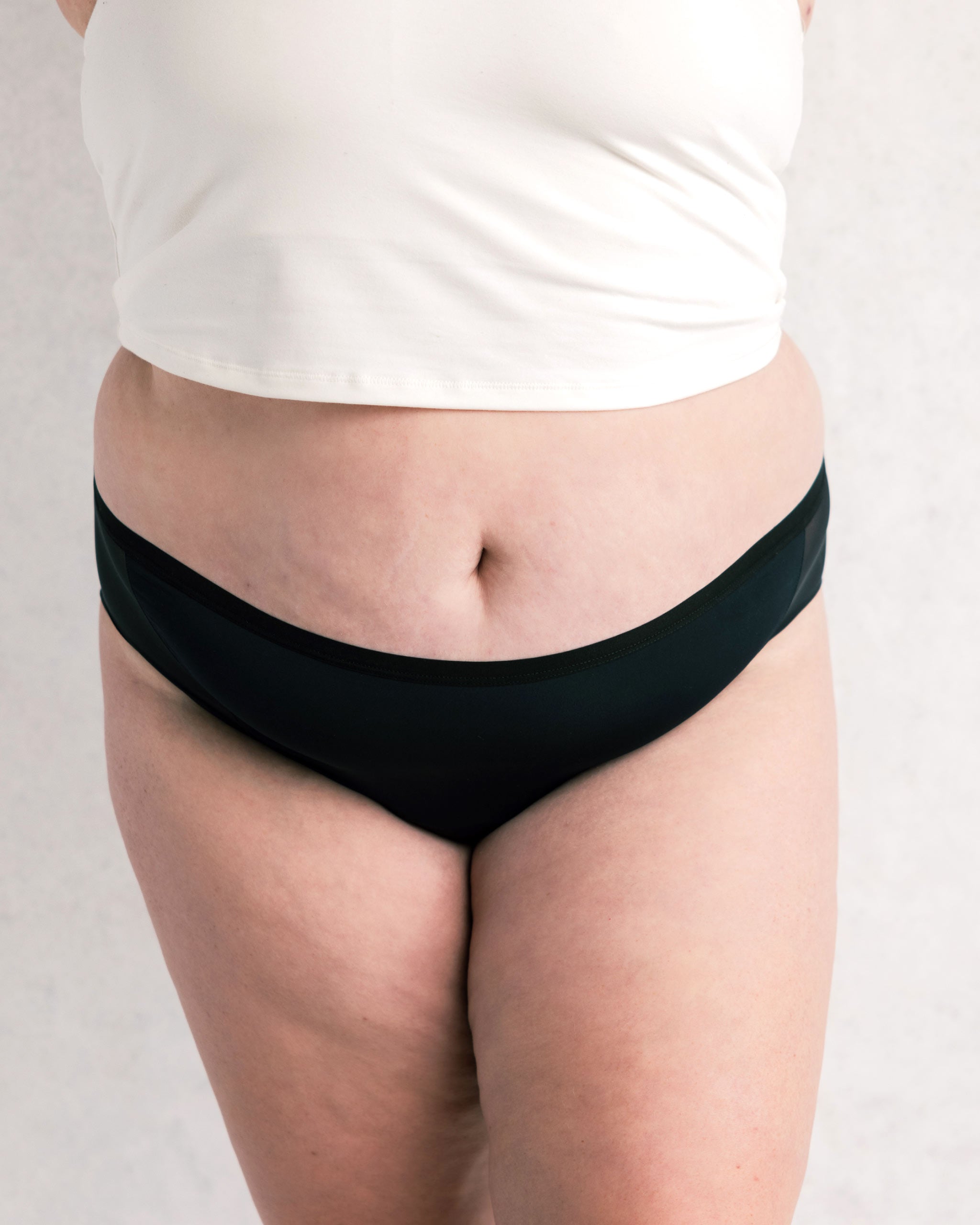 Person wearing black underwear on a plain background
