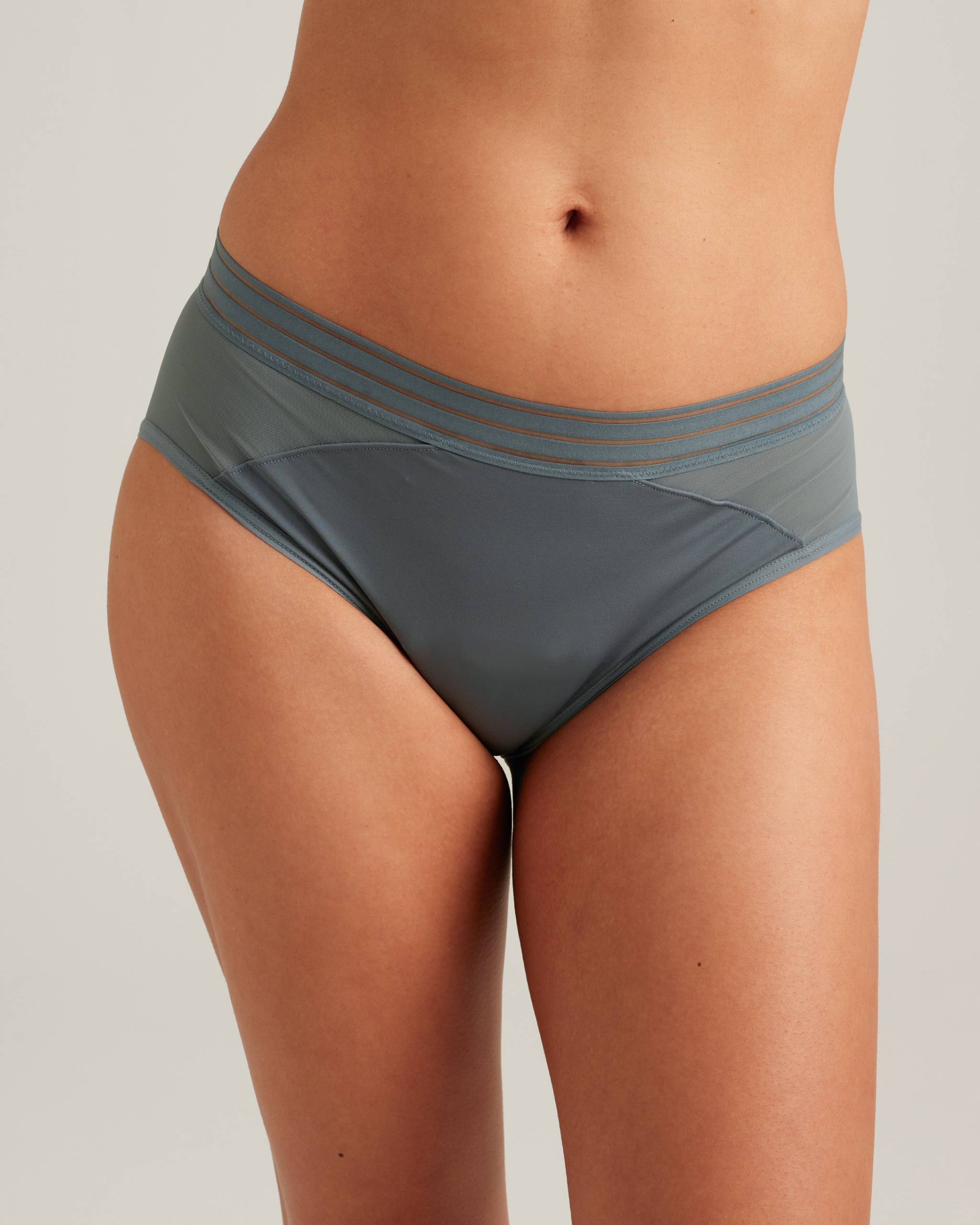Gray underwear worn by a person on a plain background