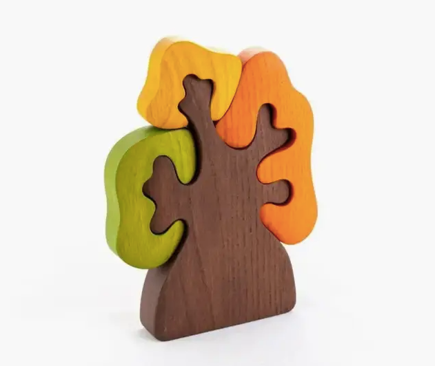Wooden tree-shaped puzzle with colorful leaves on a white background