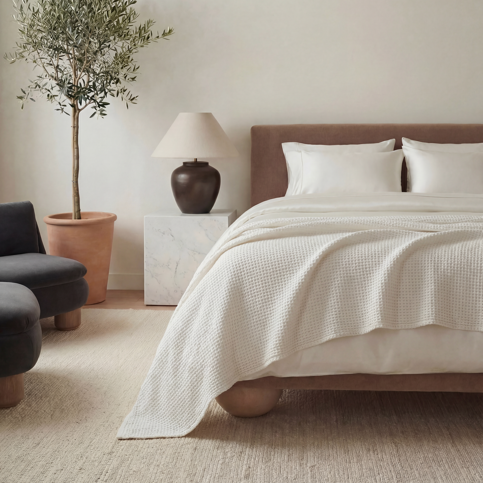 Neatly made bed with white bedding in a bedroom setting.