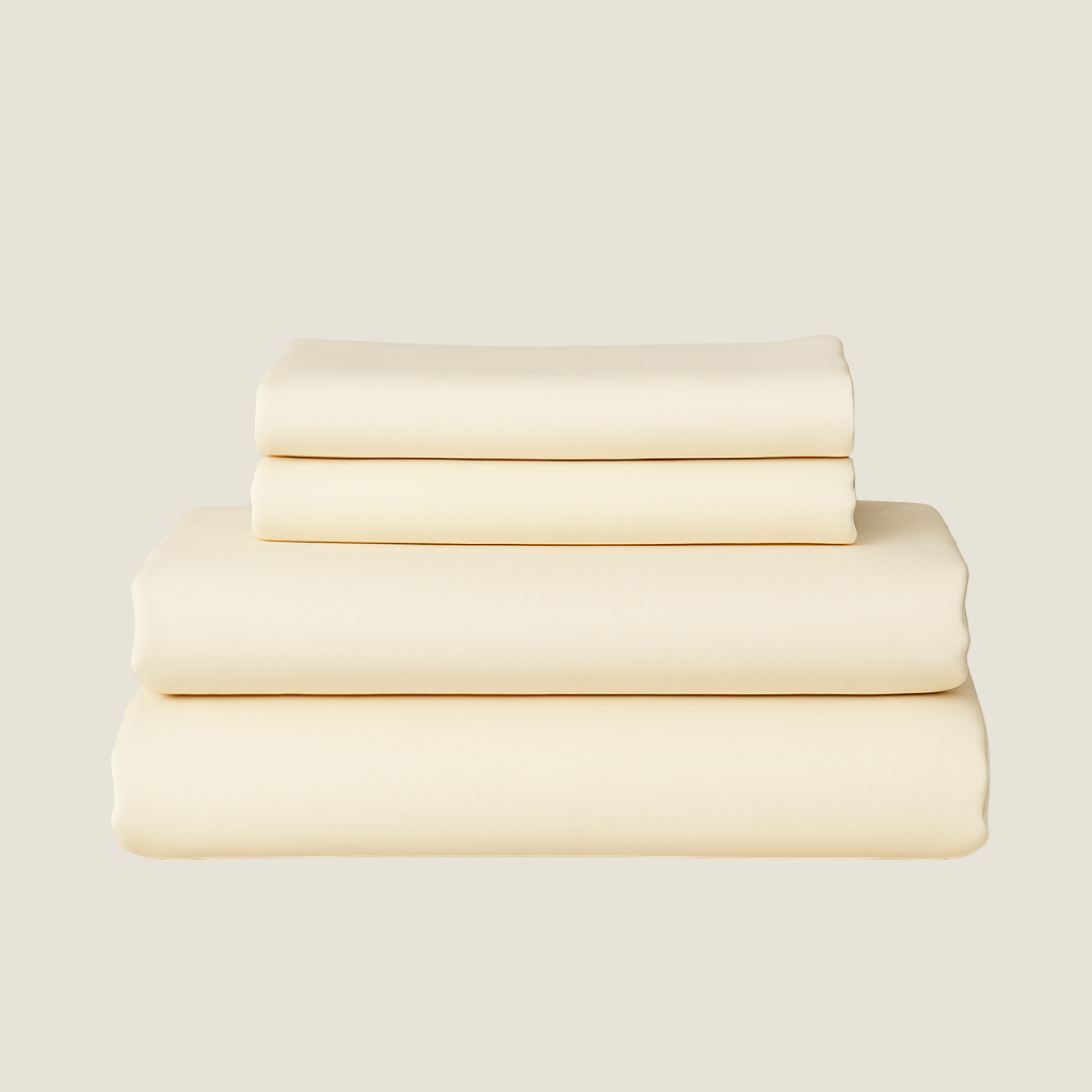 Set of cream-colored bed sheets stacked on a light beige background