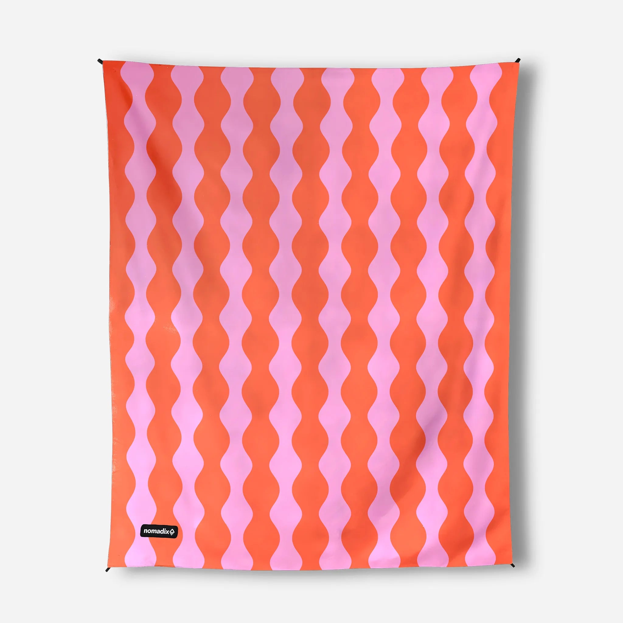 A rectangular textile product, likely a towel or blanket, featuring a repeating vertical wavy stripe pattern in vibrant orange and light pink. A small black brand label reading 'animalkid' is visible in the bottom-left corner.