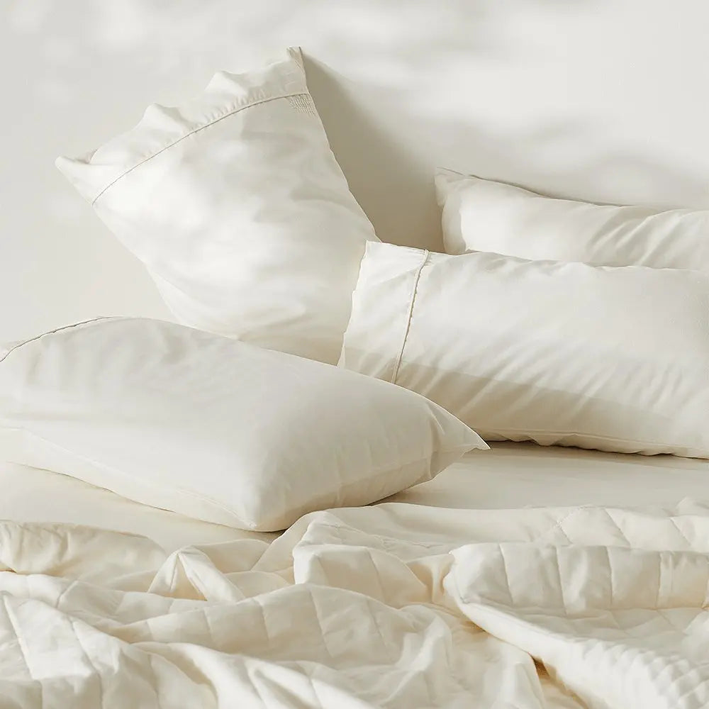 White bedding set with pillows on a light background
