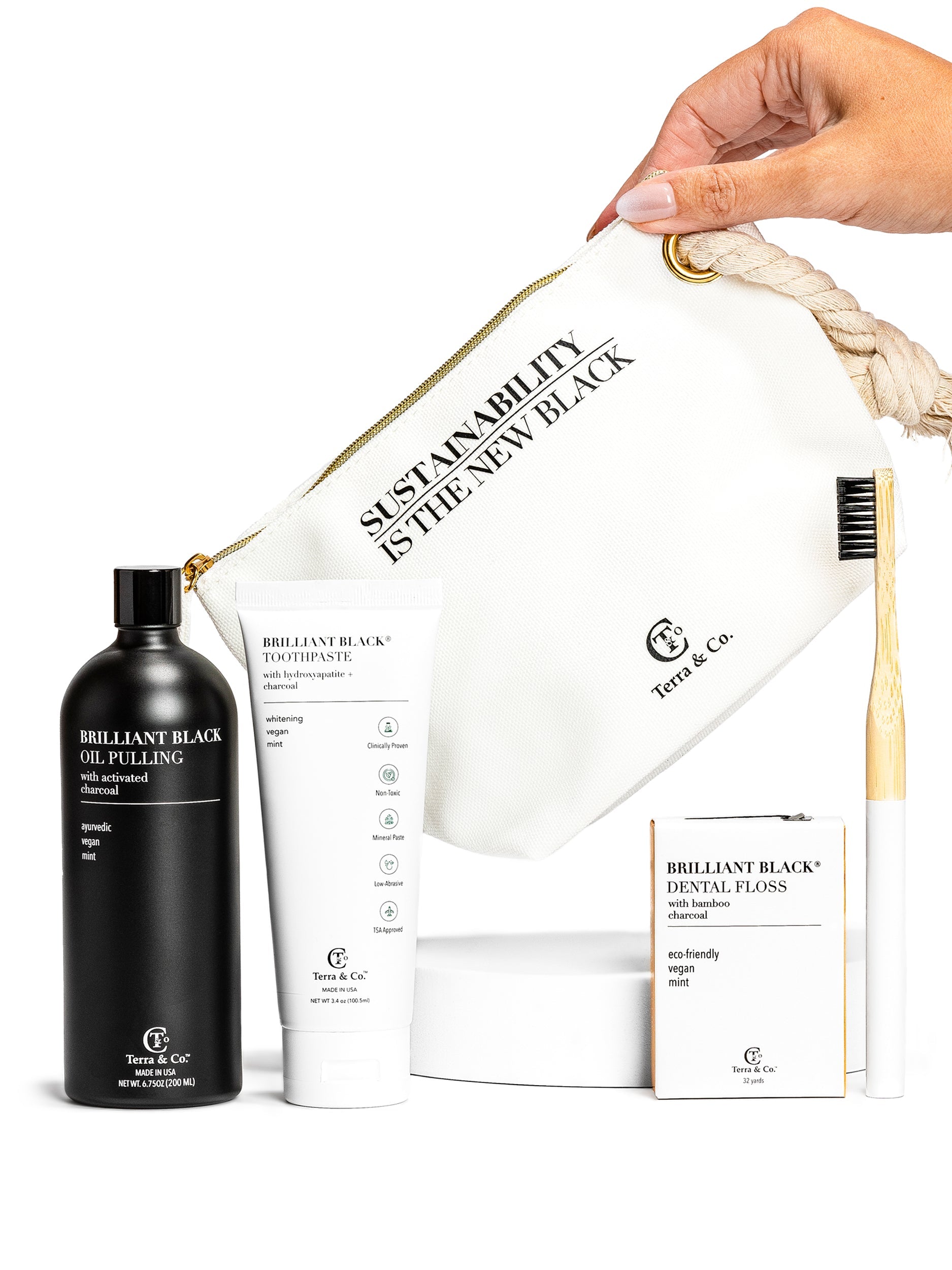 Terra & Co. Brilliant Black oil pulling product set with a hand holding a branded bag.
